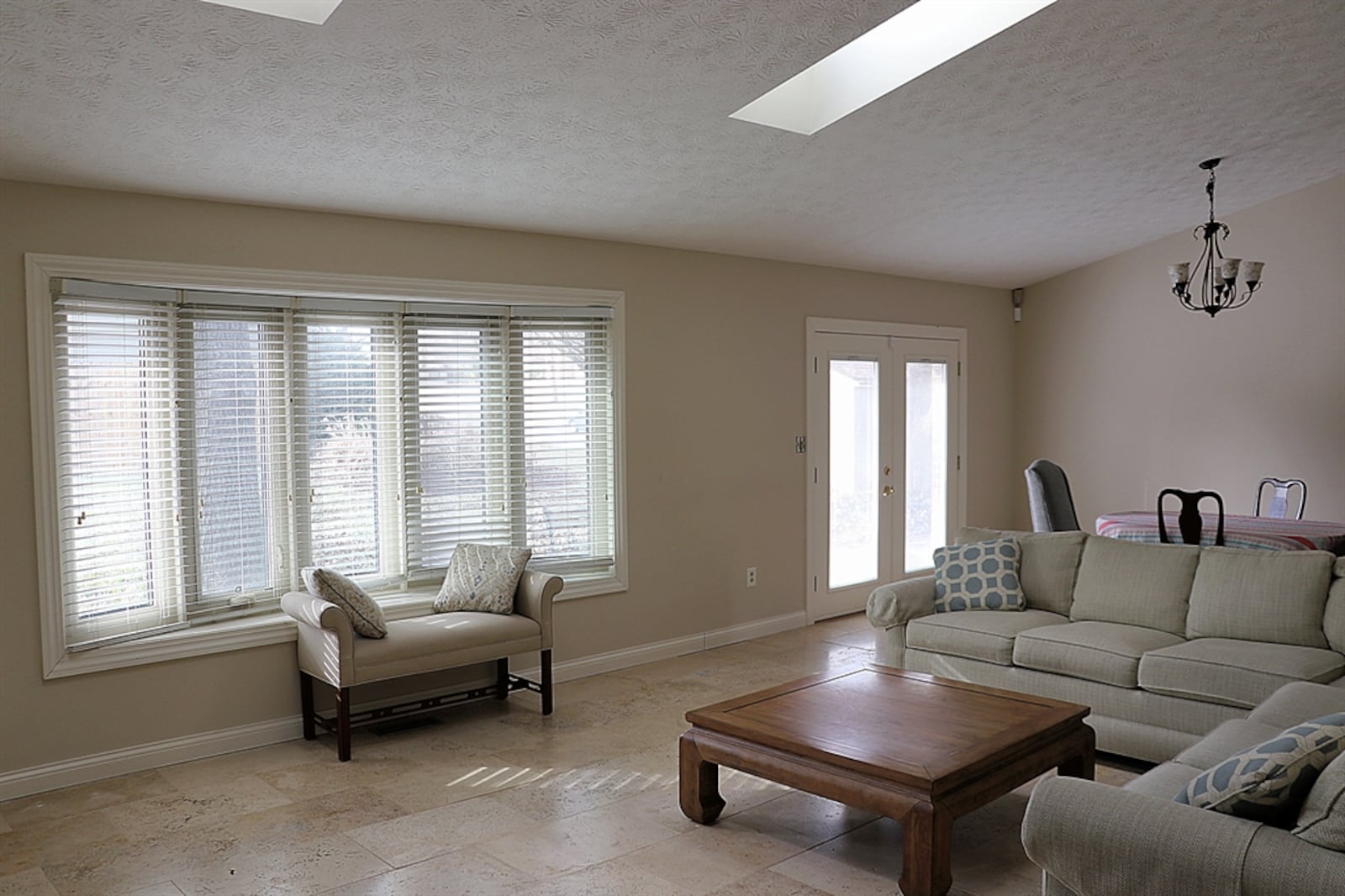 A cathedral ceiling with two skylights peaks above the great room of this tri-level home. The skylights add natural light along with the bow window and glass patio doors, allowing for a spacious feel among the main level.