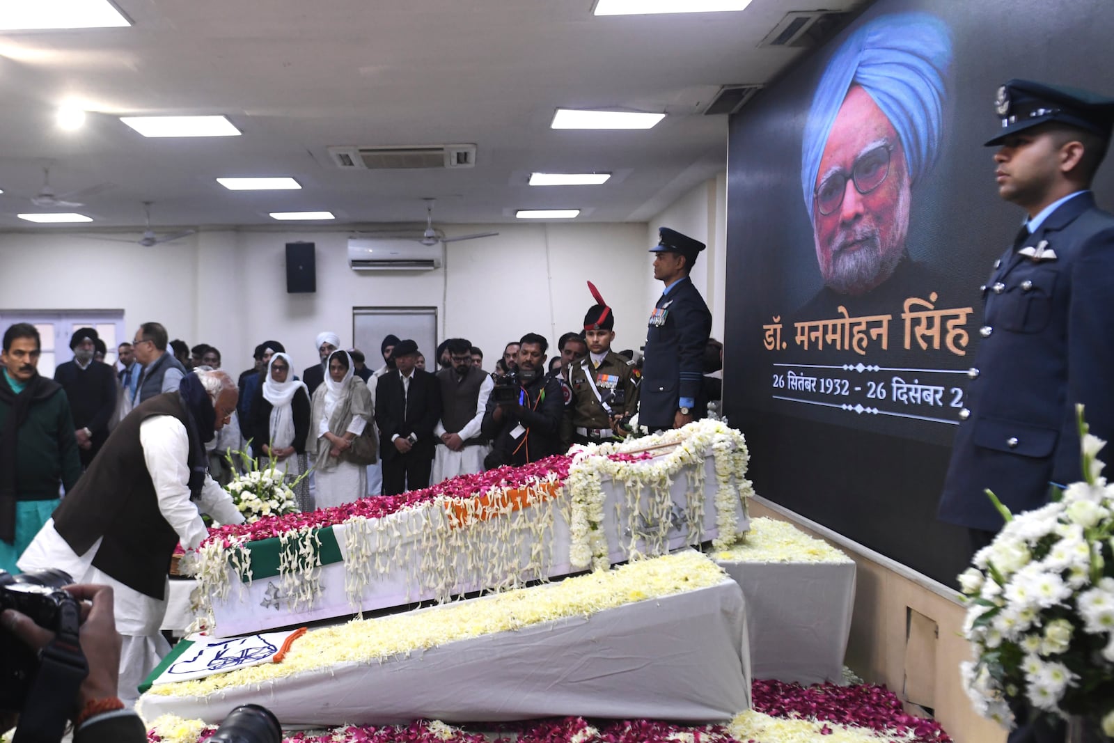 Congress party President Mallikarjun Kharge touches the casket of former Indian Prime Minister Manmohan Singh to pay his tributes at the party headquarters in New Delhi, India, Saturday, Dec. 28, 2024. (AP Photo)