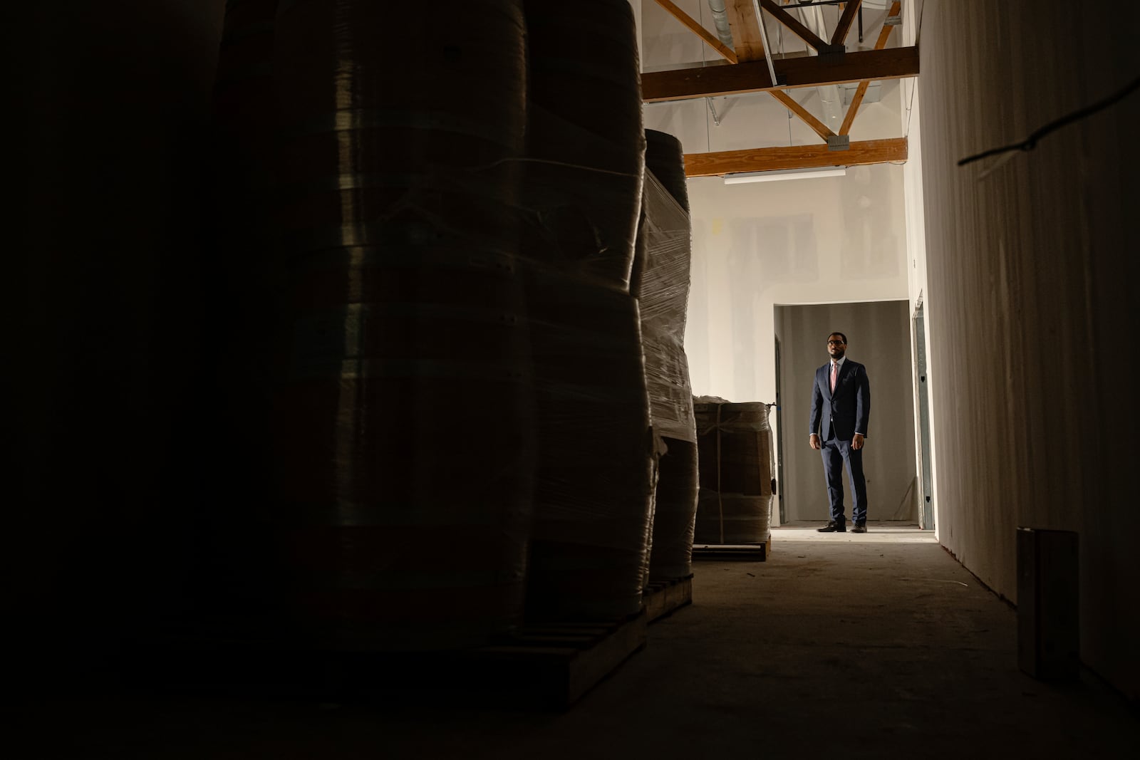 Victor Yarbrough, CEO, of the Brough Brothers Distillery poses for a photo near empty bourbon barrels under construction in Louisville, Ky., Saturday, March 8, 2025. (AP Photo/Jon Cherry)