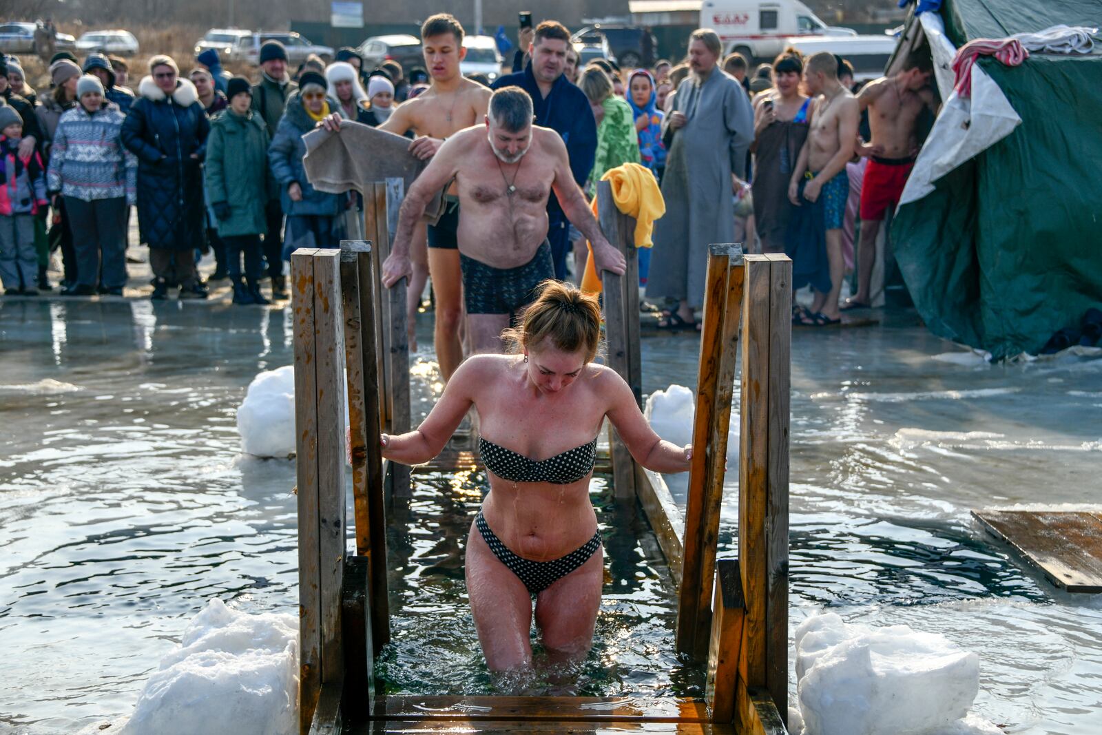 People plunge in icy water to celebrate the Orthodox Epiphany near the St. Serafimovsky Monastery on Russian Island in Russian far east port Vladivostok, Russia, Sunday, Jan. 19, 2025. (AP Photo)