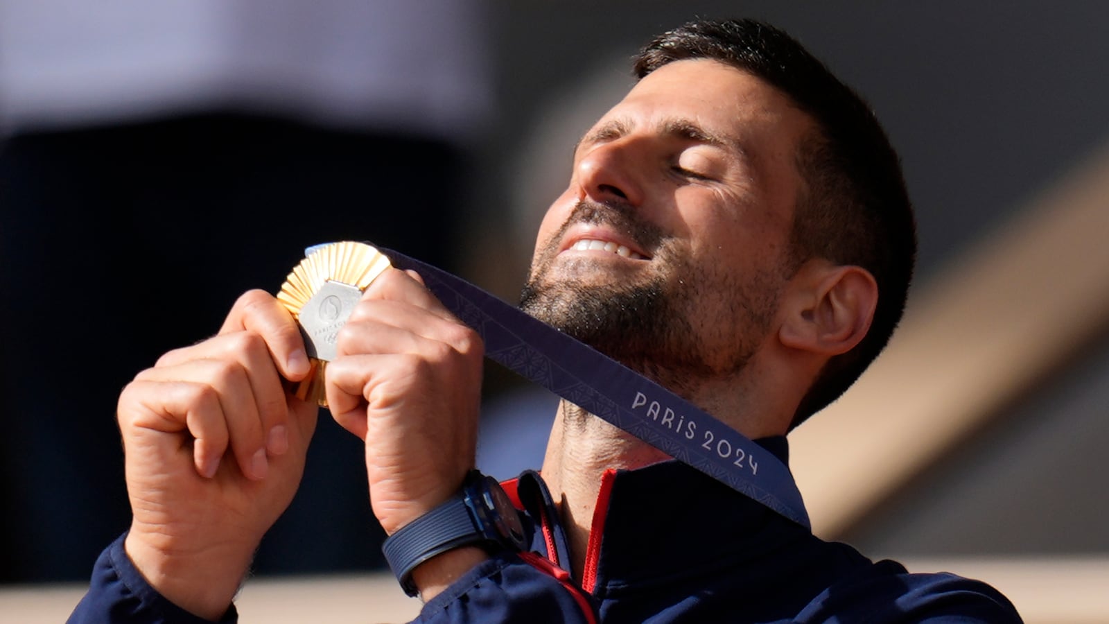 FILE - Serbia's Novak Djokovic watches his gold medal after defeating Spain's Carlos Alcaraz in the men's singles tennis final at the Roland Garros stadium during the 2024 Summer Olympics, Sunday, Aug. 4, 2024, in Paris, France. (AP Photo/Manu Fernandez, File)