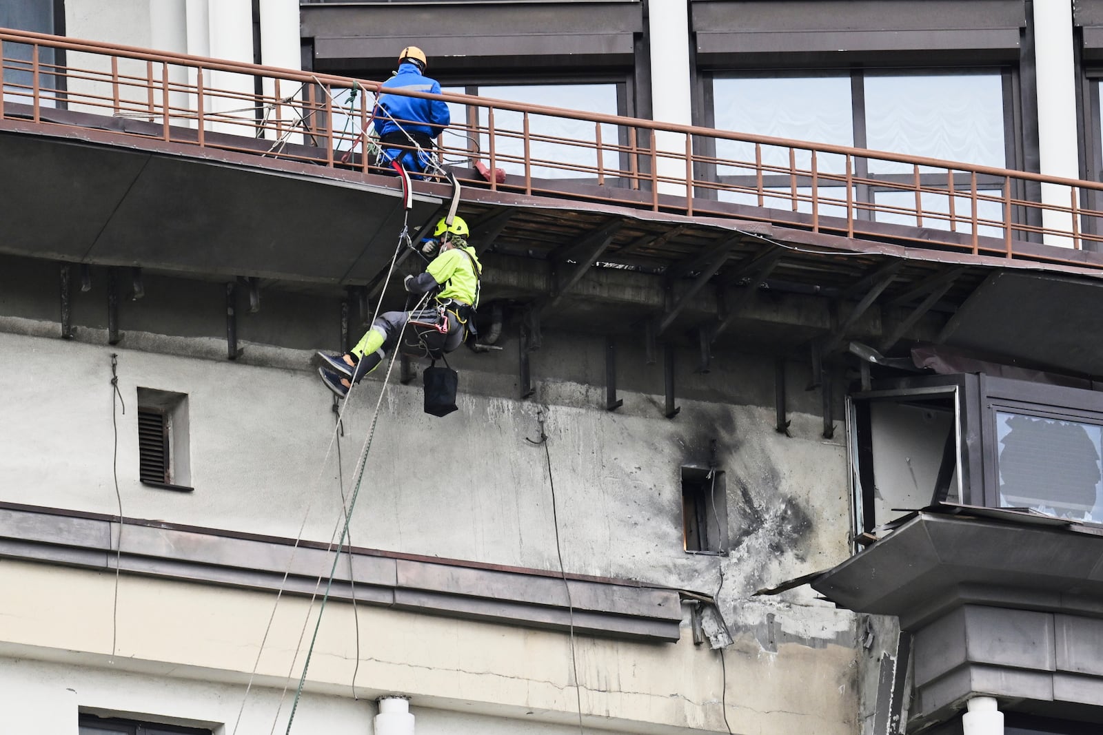 Municipal workers investigate the place after a downed Ukrainian drone damaged a building in western Moscow, Russia, Friday, March 14, 2025. (AP Photo)