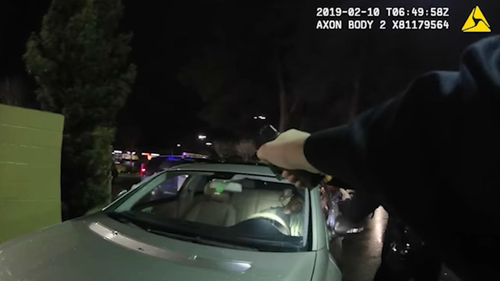 A Vallejo, California, police officer is seen pointing a gun at Willie McCoy, 20, as he sits asleep in his silver Mercedes in the drive-thru of a Taco Bell the night of Feb. 9, 2019. Six officers opened fire on McCoy, an aspiring rapper, after they say he awoke and reached for a gun in his lap.