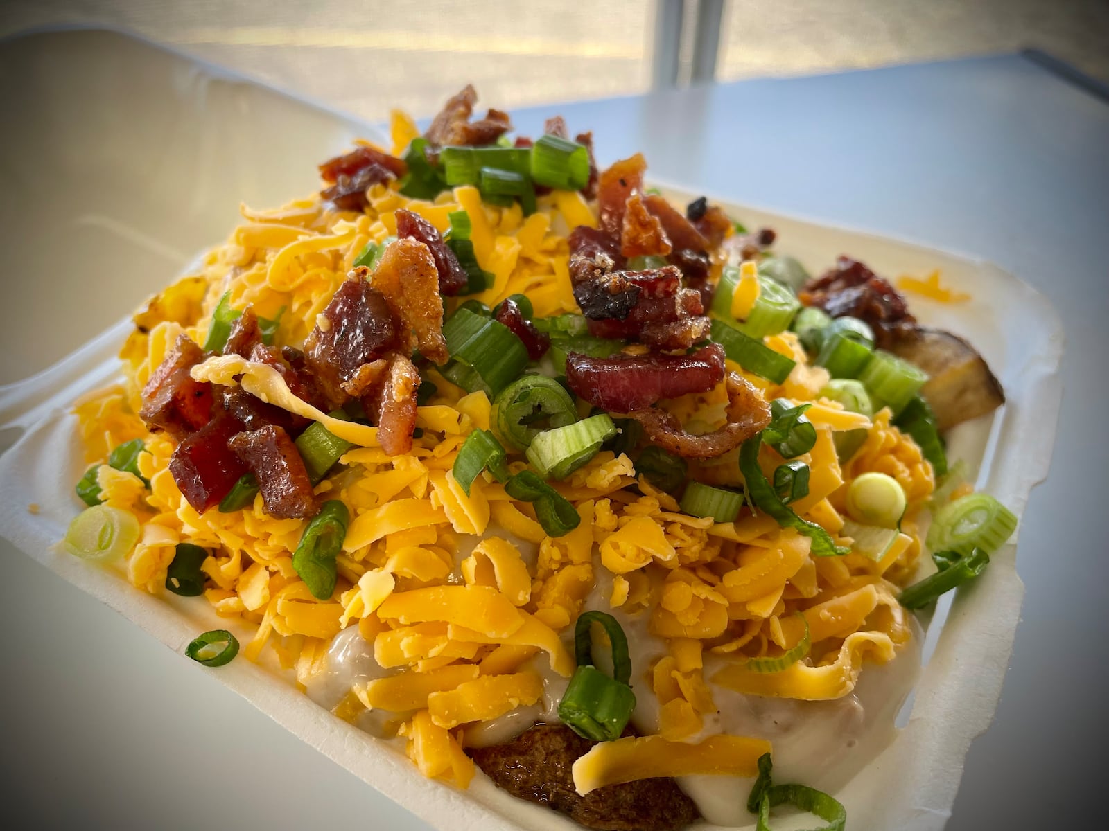 Tasty Bacon’s, a new food truck offering smash burgers, hand dipped corn dogs, loaded potatoes and breakfast items, is now serving the Fairborn area. Pictured is the Breakfast Potato Bowl with fried potatoes topped with a scrambled egg, cheese, millionaire's bacon, gravy and green onion. NATALIE JONES/STAFF