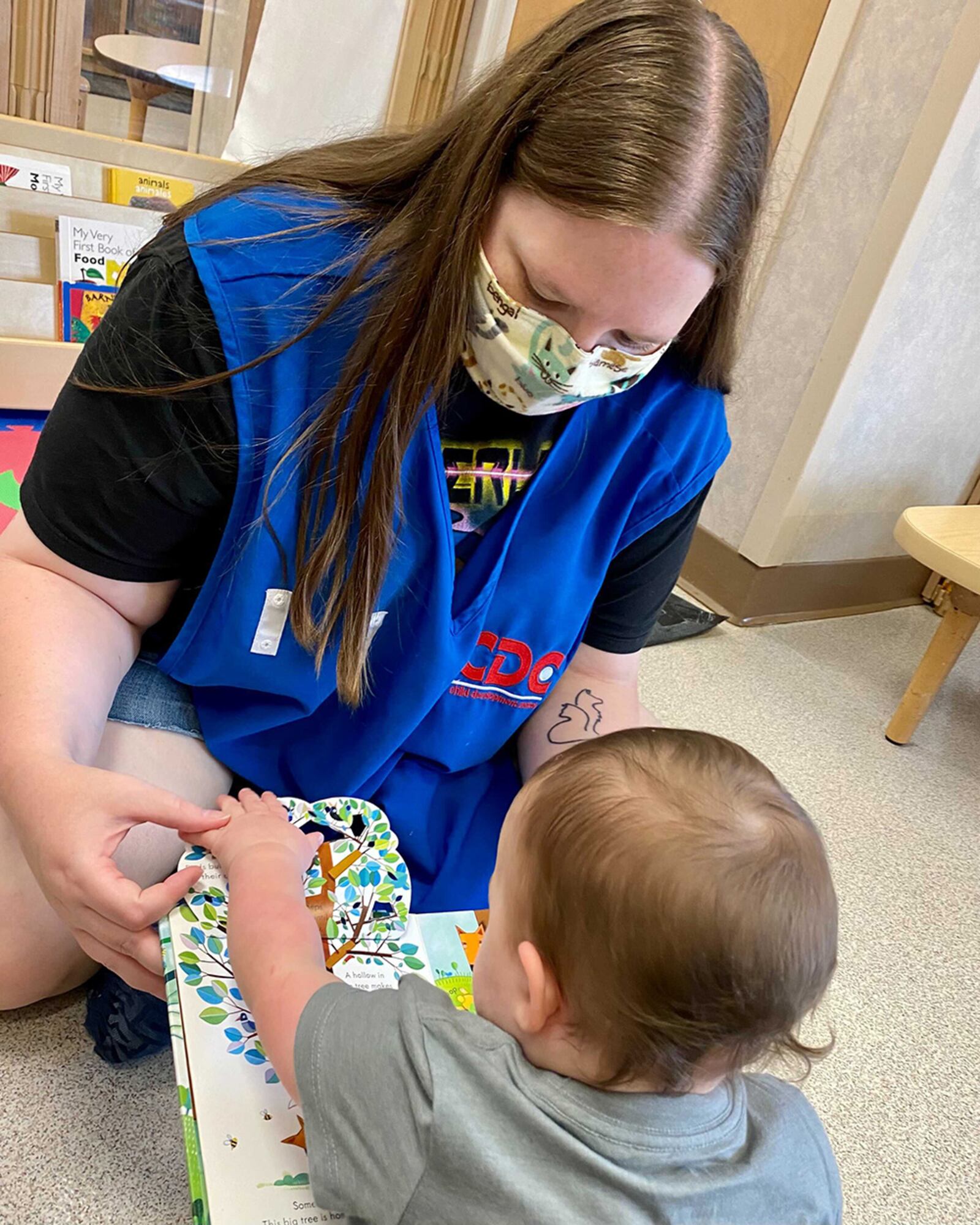 Sam Conner, a child care technician, reads a book to Georgia Rupert at the New Horizon Child Development Center on Wright-Patterson Air Force Base last June. U.S. AIR FORCE PHOTO/SENIOR AIRMAN EMILY RUPERT