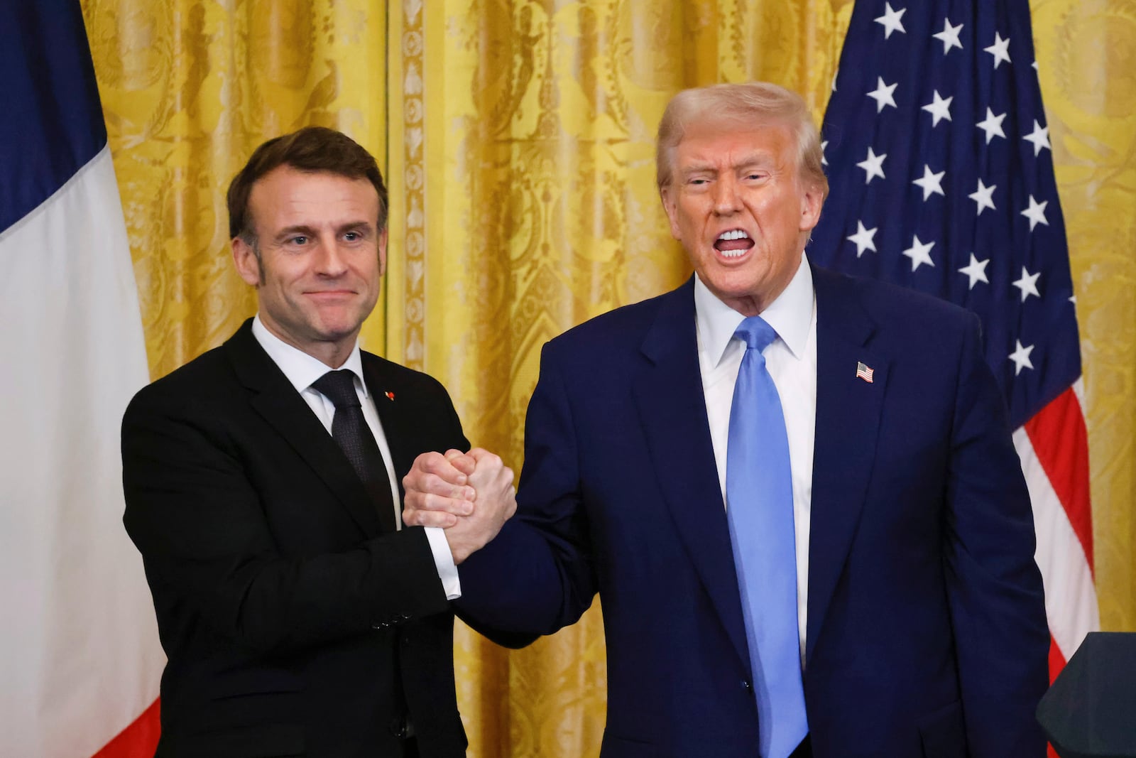 President Donald Trump, right, shakes the hand of France's President Emmanuel Macron during a joint press conference in the East Room of the White House in Washington, Monday, Feb. 24, 2025. (Ludovic Marin/Pool via AP)