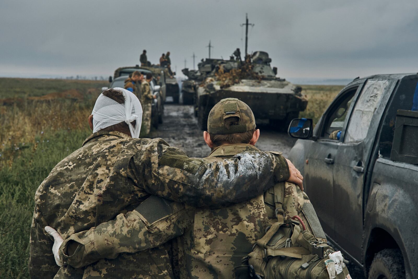 FILE - A Ukrainian soldier helps a wounded comrade on the road in reclaimed territory in the Kharkiv region, Ukraine, on Sept. 12, 2022. (AP Photo/Kostiantyn Liberov, File)