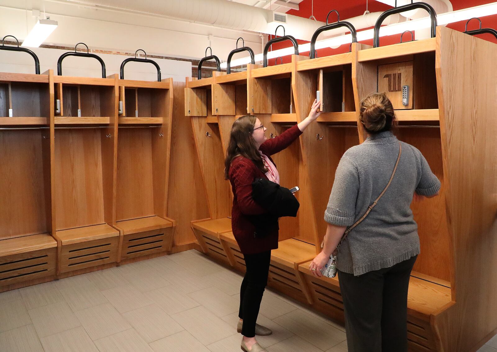 Visitors look over the new lockers in one of the locker rooms in Wittenberg's new Health, Wellness and Athletics facility. BILL LACKEY/STAFF