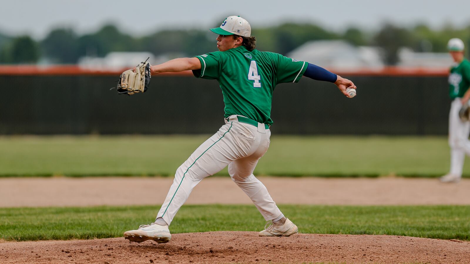 Cutline: Chaminade Julienne High School sophomore Isaac Sullivan delivers a pitch during their Division II district final game against Kenton Ridge on Thursday night at Arcanum High School. The Cougars won 3-0. Michael Cooper/CONTRIBUTED