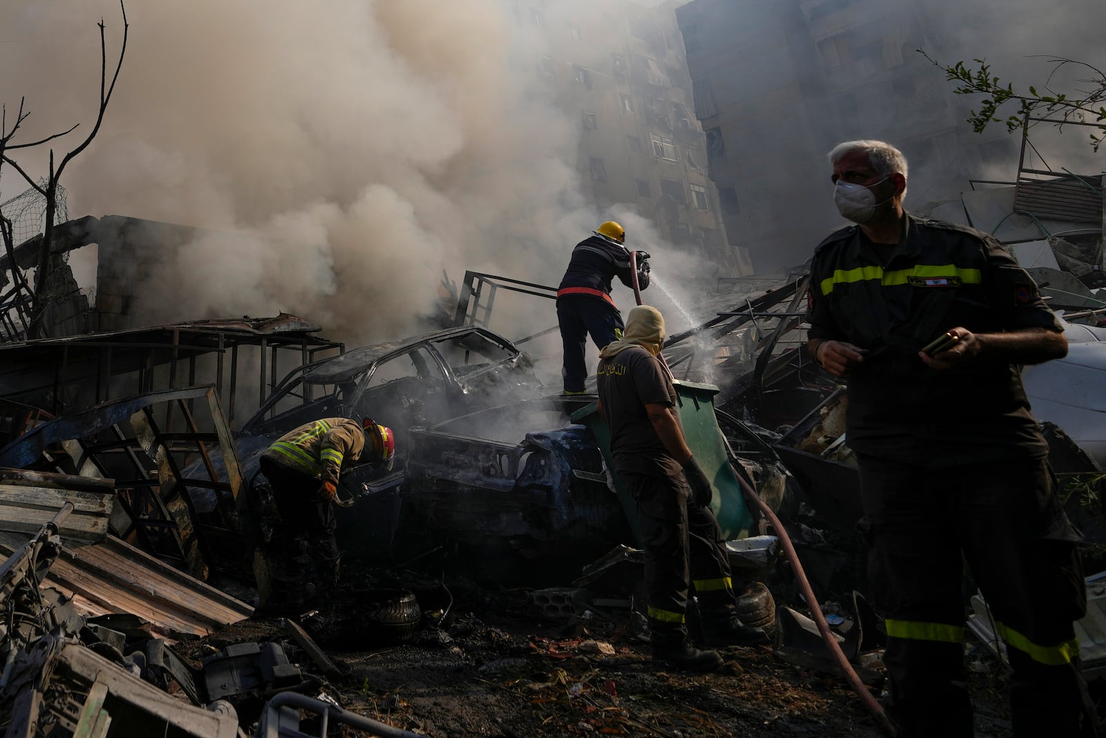 Civil defense workers extinguish a fire as smoke rises from the site of an Israeli airstrike in Dahiyeh, Beirut, Lebanon, Friday, Nov. 1, 2024. (AP Photo/Hassan Ammar)