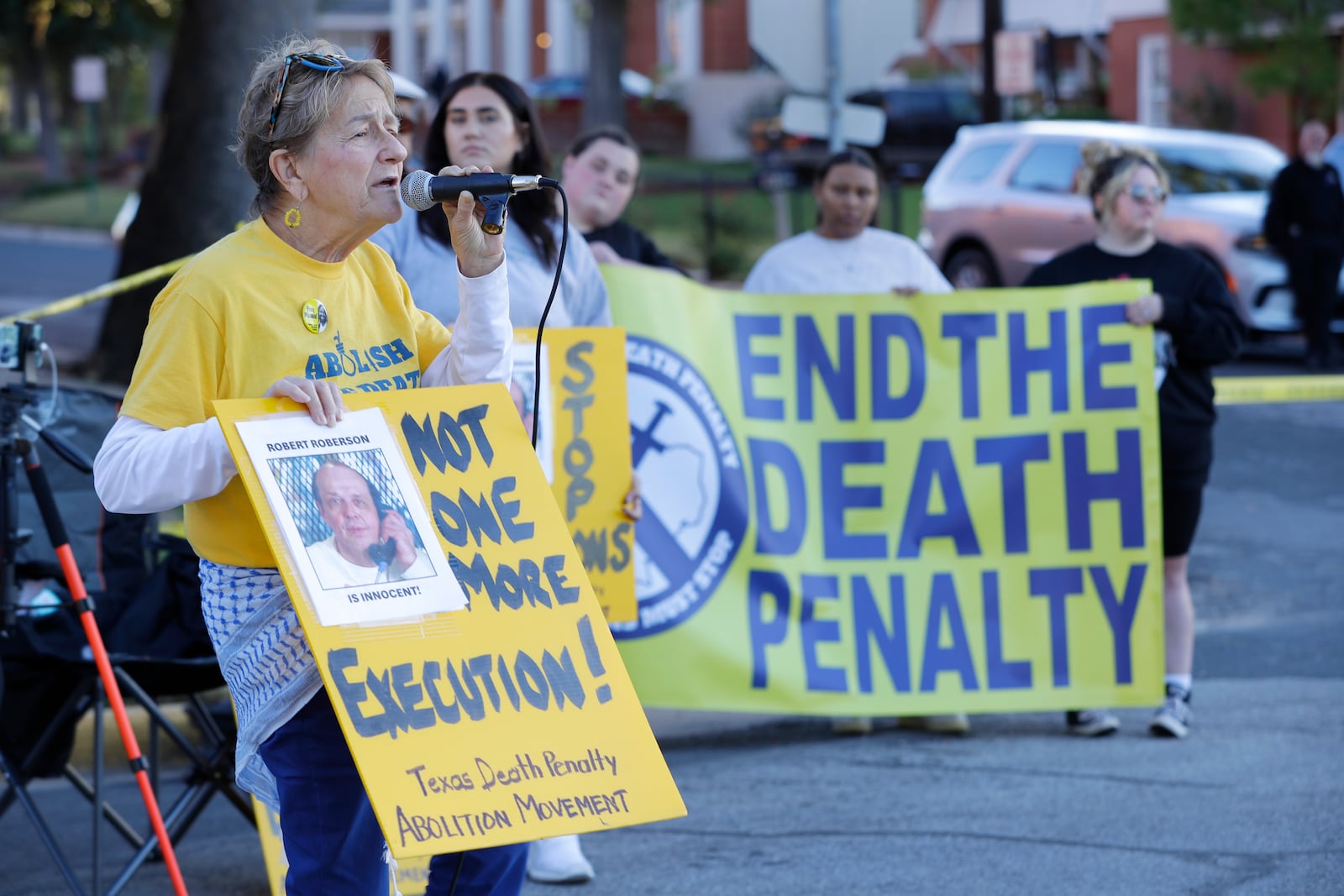 Gloria Rubac, left, an anti-death penalty activist, speaks during a protest outside the prison where Robert Roberson is scheduled for execution at the Huntsville Unit of the Texas State Penitentiary, Thursday, Oct. 17, 2024, in Huntsville, Texas. (AP Photo/Michael Wyke)