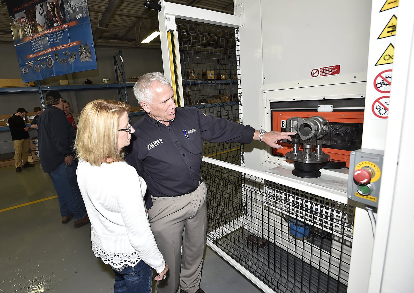 Jack Palmer, owner of Palmer Manufacturing, shows his wife, Matti, a new grinding machine during a tour of their new facility follow a ribbon cutting. The new expansion is part of a joint venture with Maus, an Italian firm, that may lead to new jobs. Bill Lackey/Staff