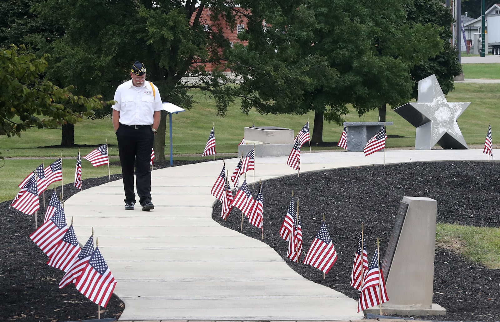 Craig Bennett, one of the organizers of the Champaign County 9/11 Memorial Ceremony, makes his way along the walkway at Freedom Grove Friday. BILL LACKEY/STAFF