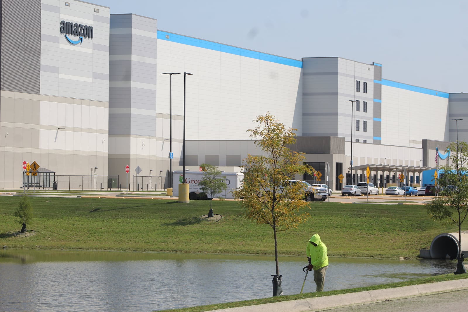 Landscaping crews work on the entrance to the new Amazon fulfillment center near the Dayton International Airport in Union. CORNELIUS FROLIK / STAFF