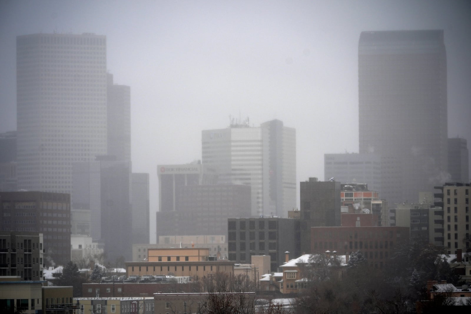 A light snow shrouds the skyline as a winter storm sweeps over the intermountain West, plunging temperatures into the single digits and bringing along a light snow in its wake Saturday, Jan. 18, 2025, in Denver. (AP Photo/David Zalubowski)