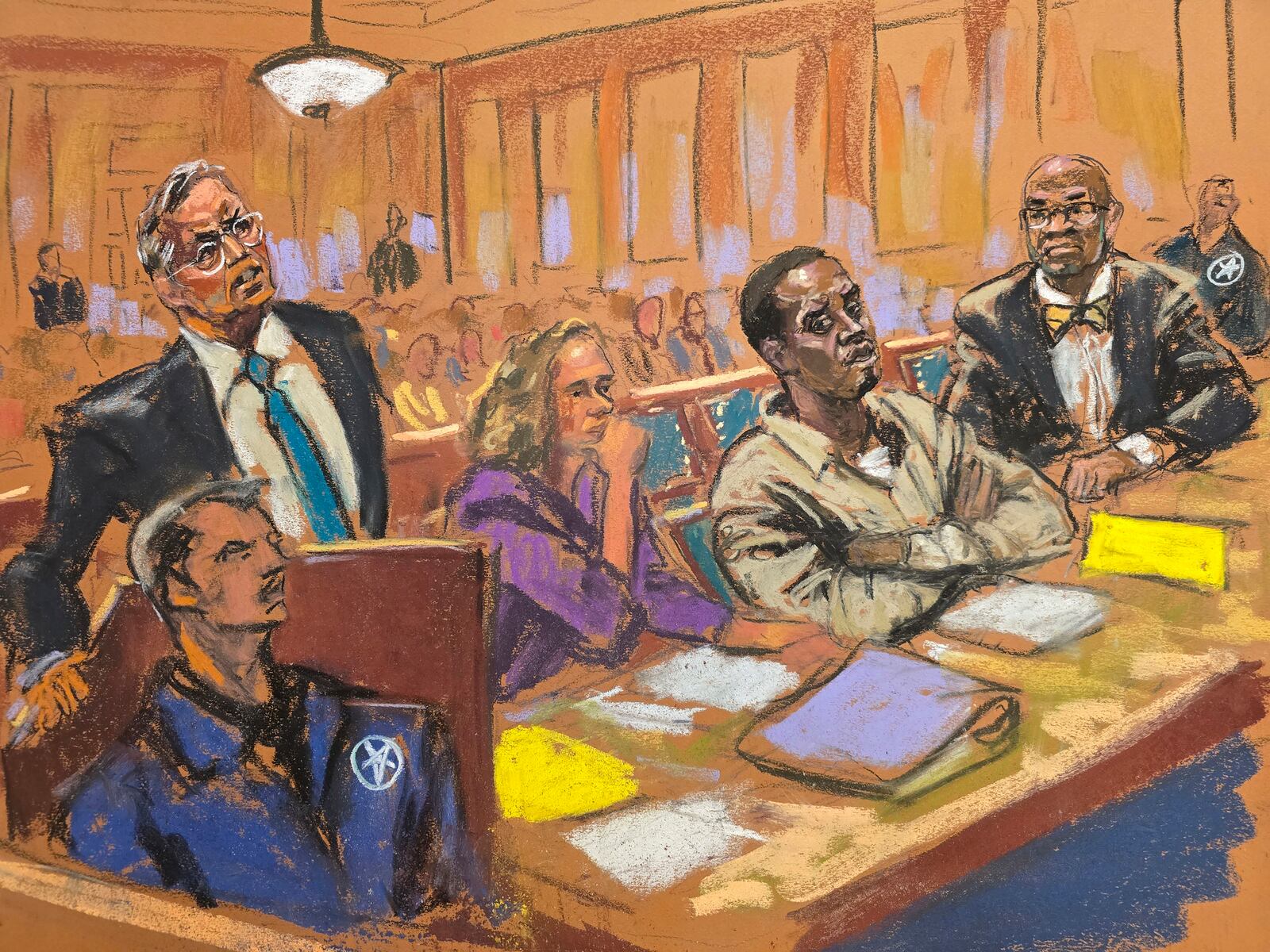 In this courtroom sketch, attorney Marc Agnifolo, left, speaks at the podium, as Alexandra Shapiro, Sean Diddy Combs, and attorney Tony Riccio, seated second left to right, listen during a hearing in federal court, Friday, Nov. 24, 2024, in New York. (Jane Rosenberg via AP)