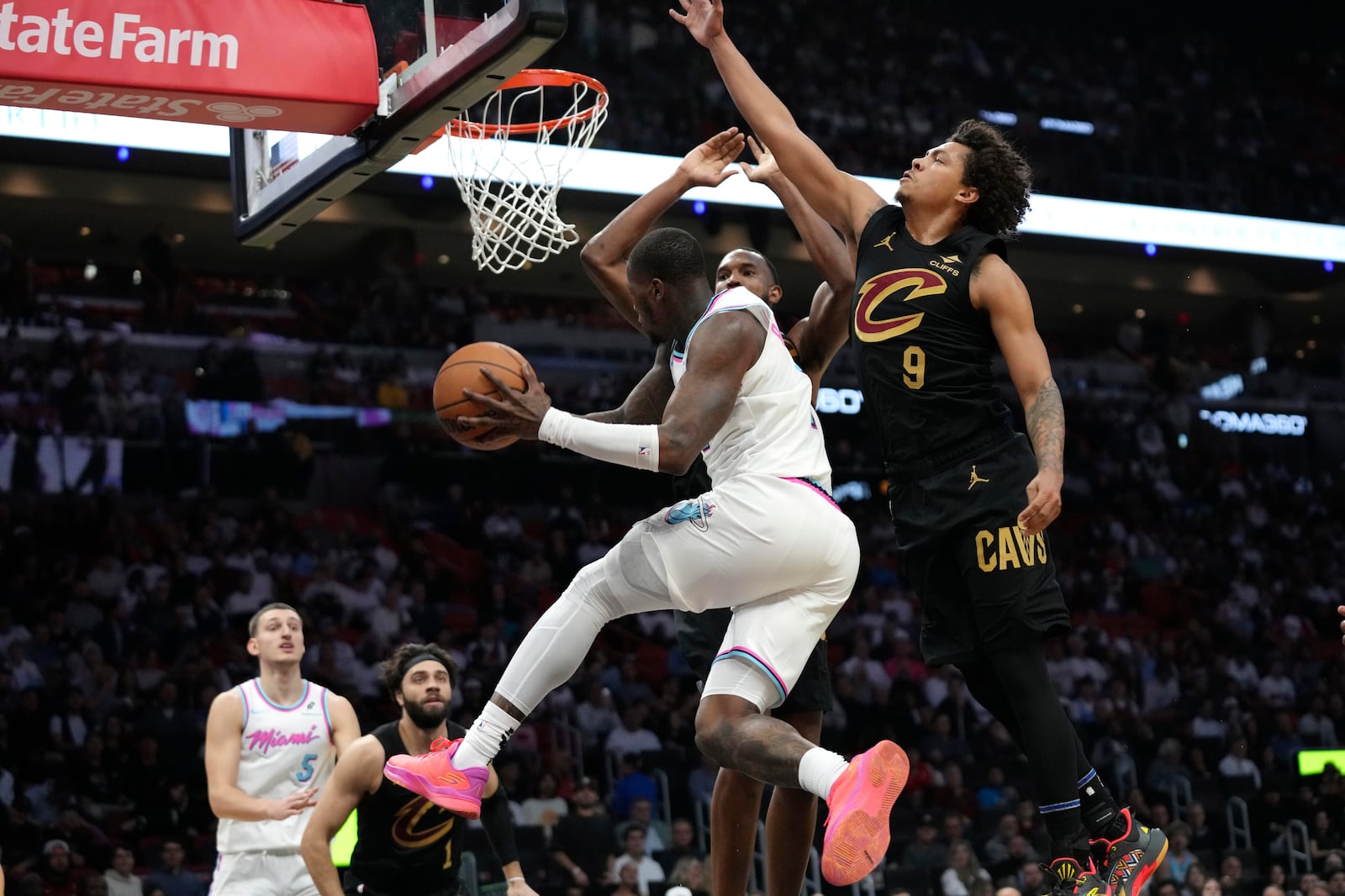 Miami Heat guard Terry Rozier, center, looks to pass as Cleveland Cavaliers guard Craig Porter Jr. (9) defends during the first half of an NBA basketball game, Wednesday, Jan. 29, 2025, in Miami. (AP Photo/Lynne Sladky)