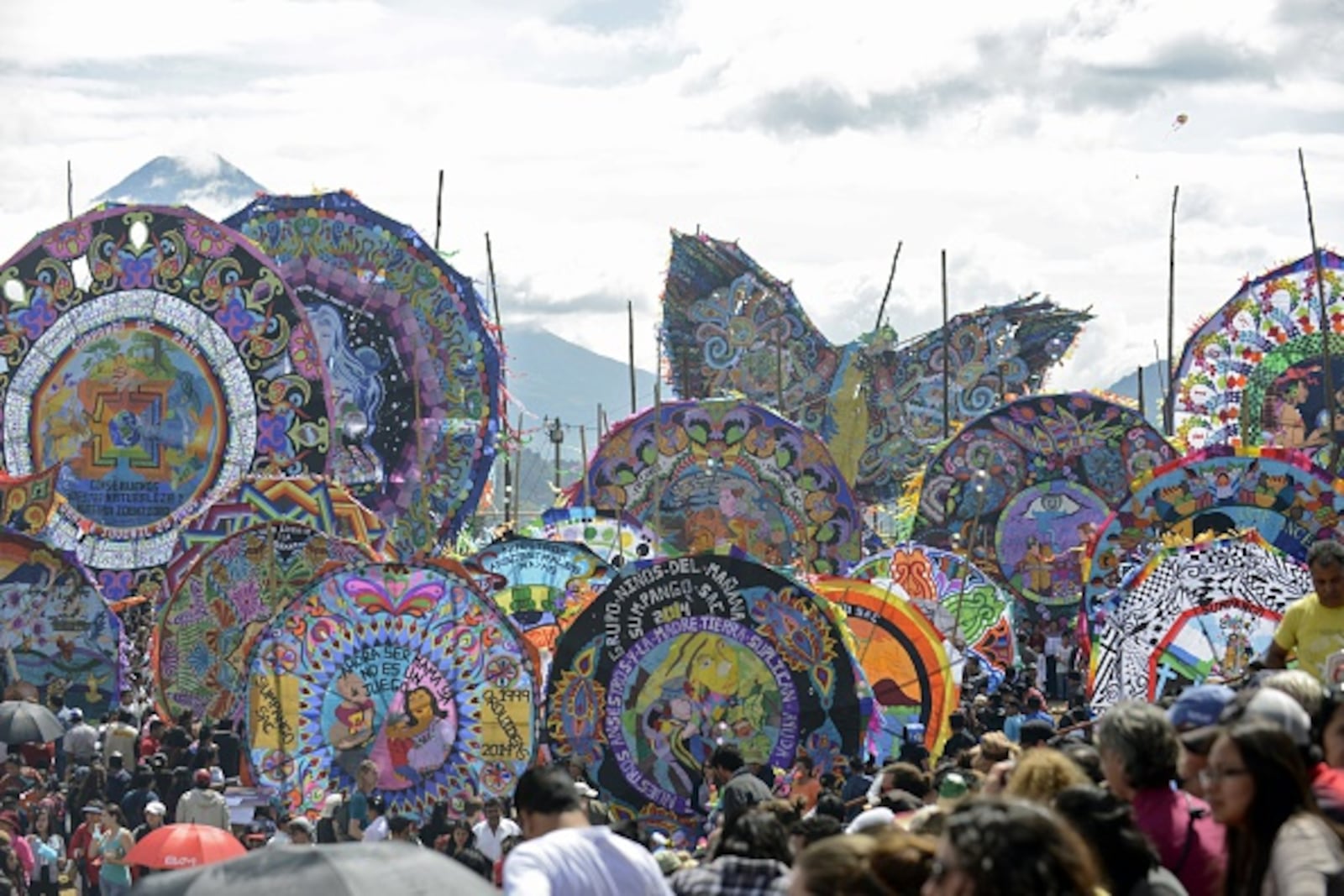 People gather with giant kites at Sumpango municipality, Sacatepequez departament, some 48 km west of Guatemala City, during All Saints' Day, on November 1, 2014. AFP PHOTO/Johan ORDONEZ (Photo credit should read JOHAN ORDONEZ/AFP/Getty Images)