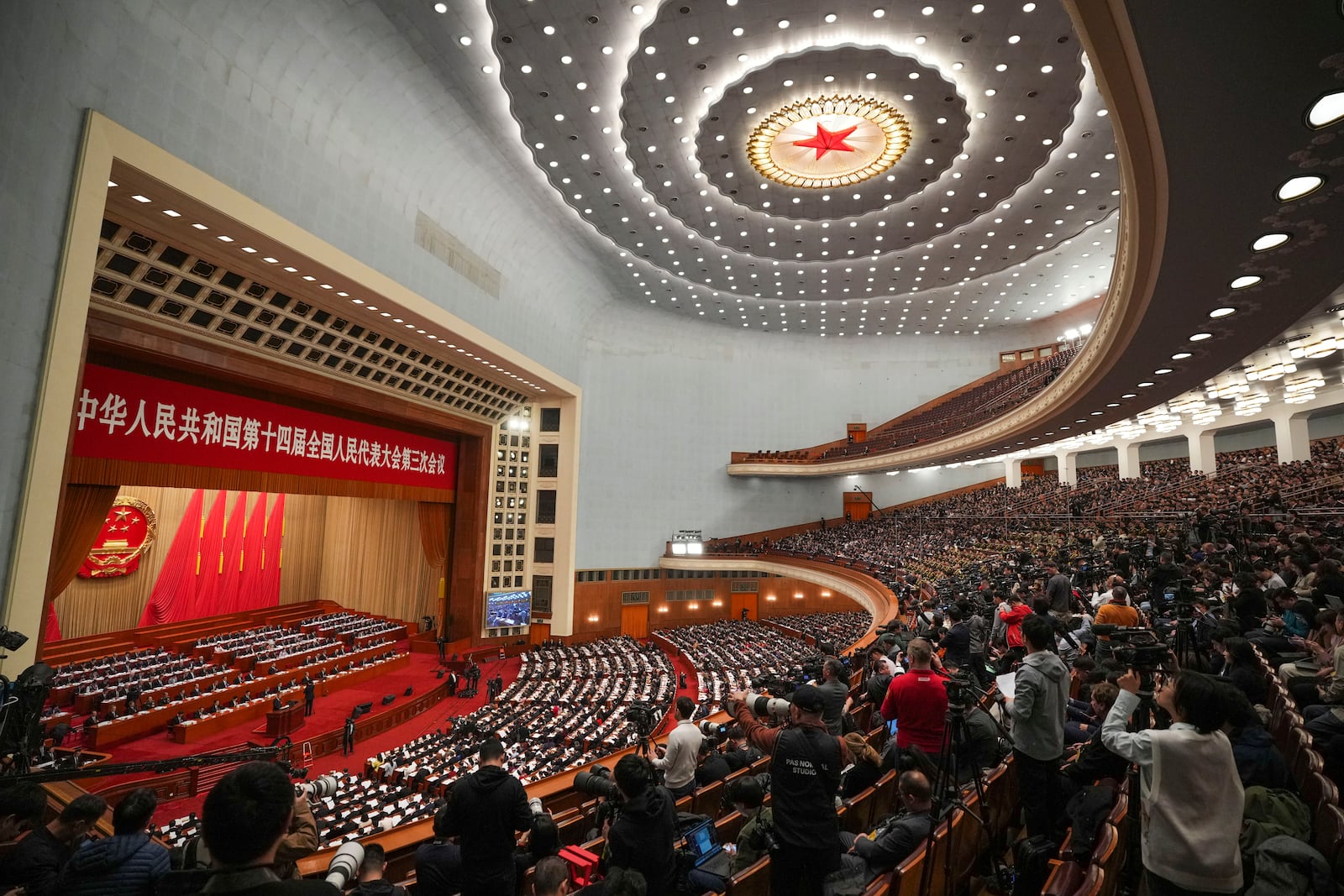 Delegates and media attend the opening session of the National People's Congress (NPC) at the Great Hall of the People in Beijing, China, Wednesday, March 5, 2025. (AP Photo/Vincent Thian)