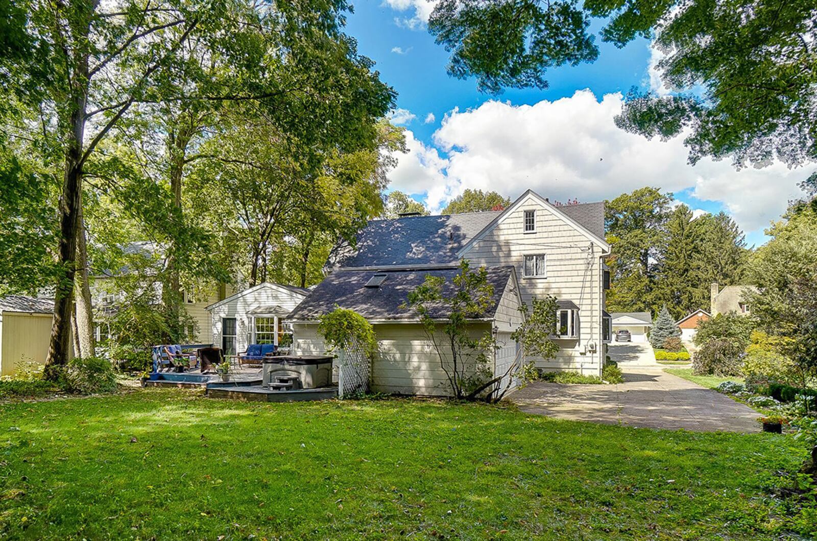 The rear of the home has a double wood deck with partial railing and a hot tub. A concrete drive leads behind the house to the detached, 2-car garage. CONTRIBUTED PHOTO