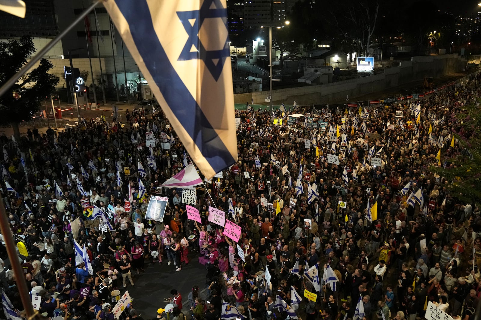 People gather to protest against Prime Minister Benjamin Netanyahu's government and call for the release of hostages held in the Gaza Strip by the Hamas militant group, in Tel Aviv, Israel, Saturday, Nov. 23, 2024. (AP Photo/Maya Alleruzzo)