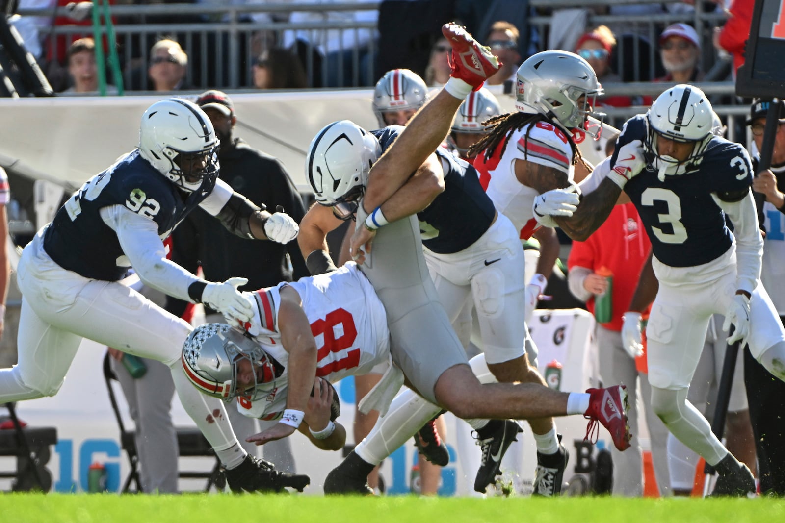 Ohio State quarterback Will Howard (18) is tackled by Penn State linebacker Dominic DeLuca (0) during the third quarter of an NCAA college football game, Saturday, Nov. 2, 2024, in State College, Pa. (AP Photo/Barry Reeger)