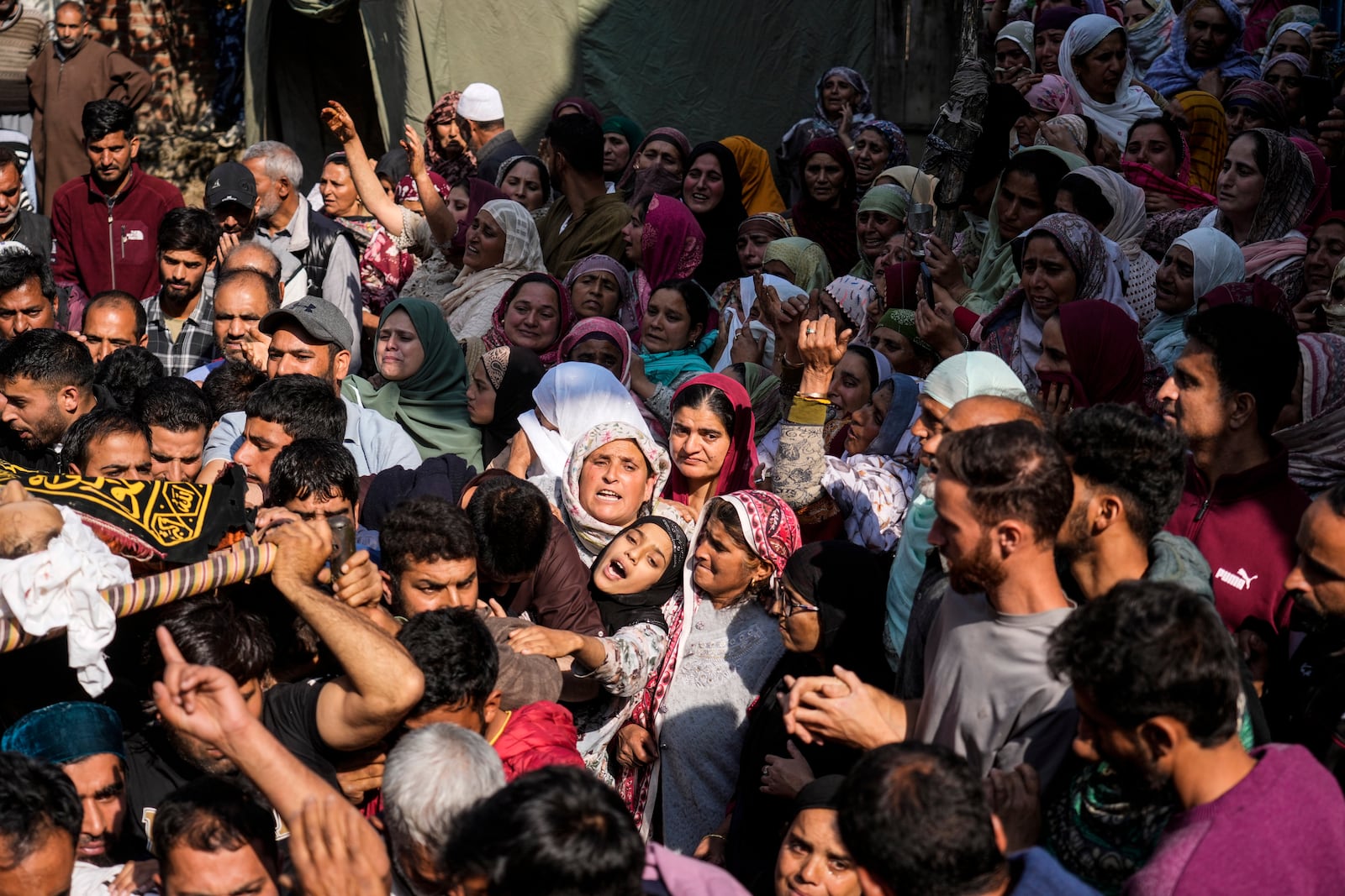 Relatives wail near the body of Kashmiri doctor Shahnawaz who was among those killed when gunmen fired at people working on a strategic tunnel project in Indian-controlled Kashmir, during his funeral at Nadigam village, southwest of Srinagar, Monday, Oct. 21, 2024. (AP Photo/Mukhtar Khan)