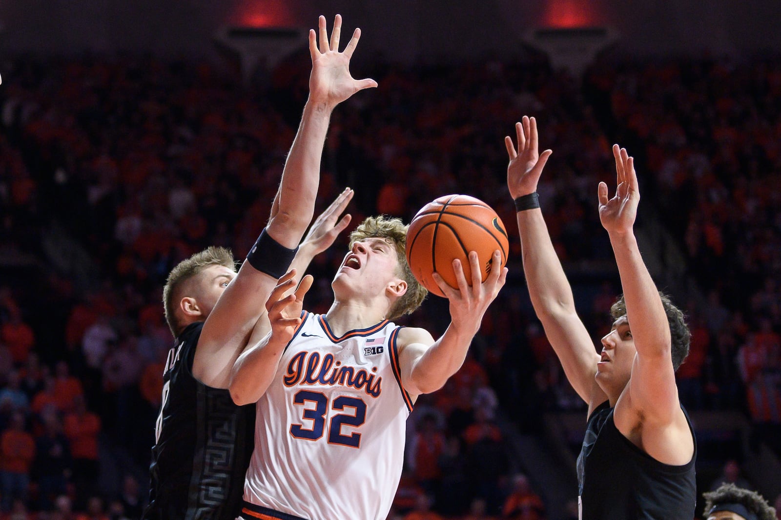 Illinois' Kasparas Jakucionis attempts a shot between Michigan State's Jaxon Kohler, left, and Szymon Zapala during an NCAA college basketball game Saturday, Feb. 15, 2025, in Champaign, Ill. (AP Photo/Craig Pessman)