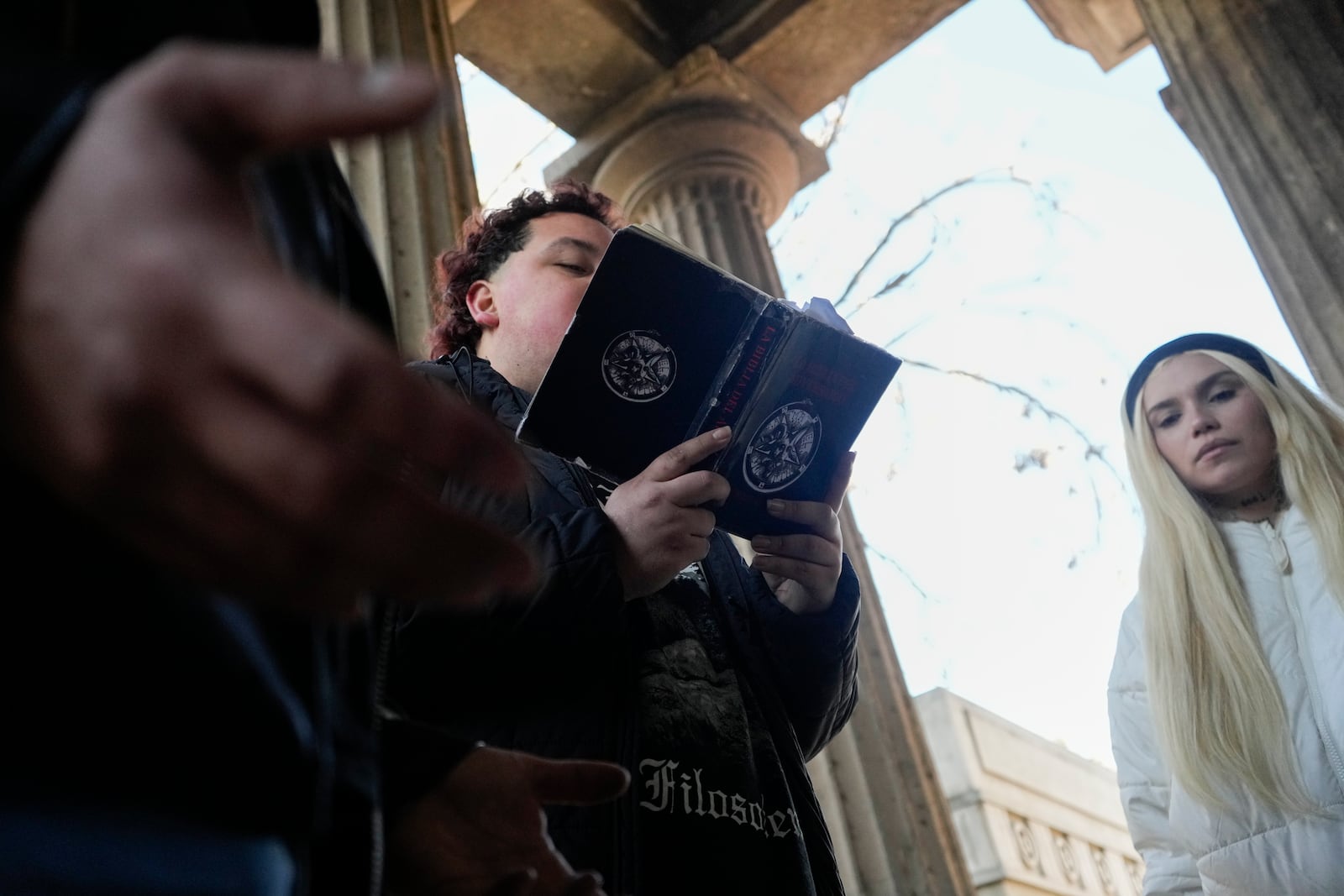 A member of The Temple of Satan: Satanists and Luciferians of Chile reads from The Bible of the Adversary by Michael Ford, during a ceremony at the General Cemetery in Santiago, Saturday, Sept. 14, 2024. (AP Photo/Esteban Felix)