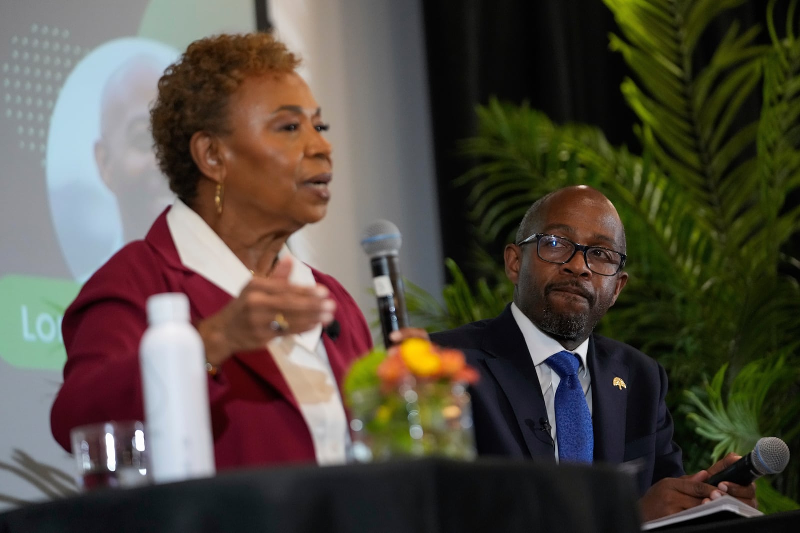 Loren Taylor, right, listens as fellow Oakland mayoral candidate Barbara Lee answers a question during a debate Tuesday, March 11, 2025, in Oakland, Calif. (AP Photo/Godofredo A. Vásquez)