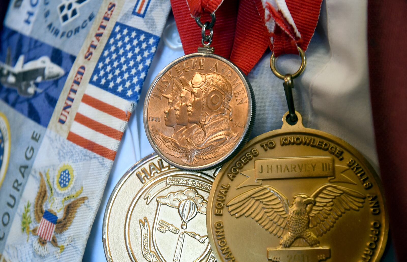 Medals are draped around the neck of 101-year-old Col. James H. Harvey III, one of the last surviving Tuskegee Airmen, at the Veterans Community Living Center in Aurora, Colo., Wednesday, March 12, 2025. (AP Photo/Thomas Peipert)