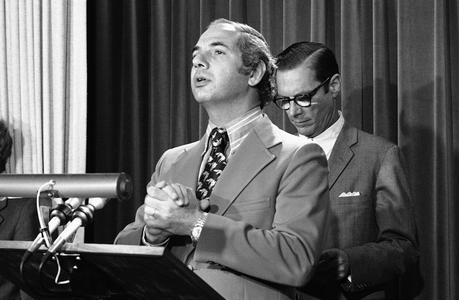 FILE - Press Secretary Ron Nessen and Treasury Secretary Williams Simon, background, brief reporters, May 14, 1975, in Washington. Nessen, a veteran broadcast journalist who served as Ford's press secretary, died March 12, 2025. He was 90. (AP Photo/John Duricka, File)