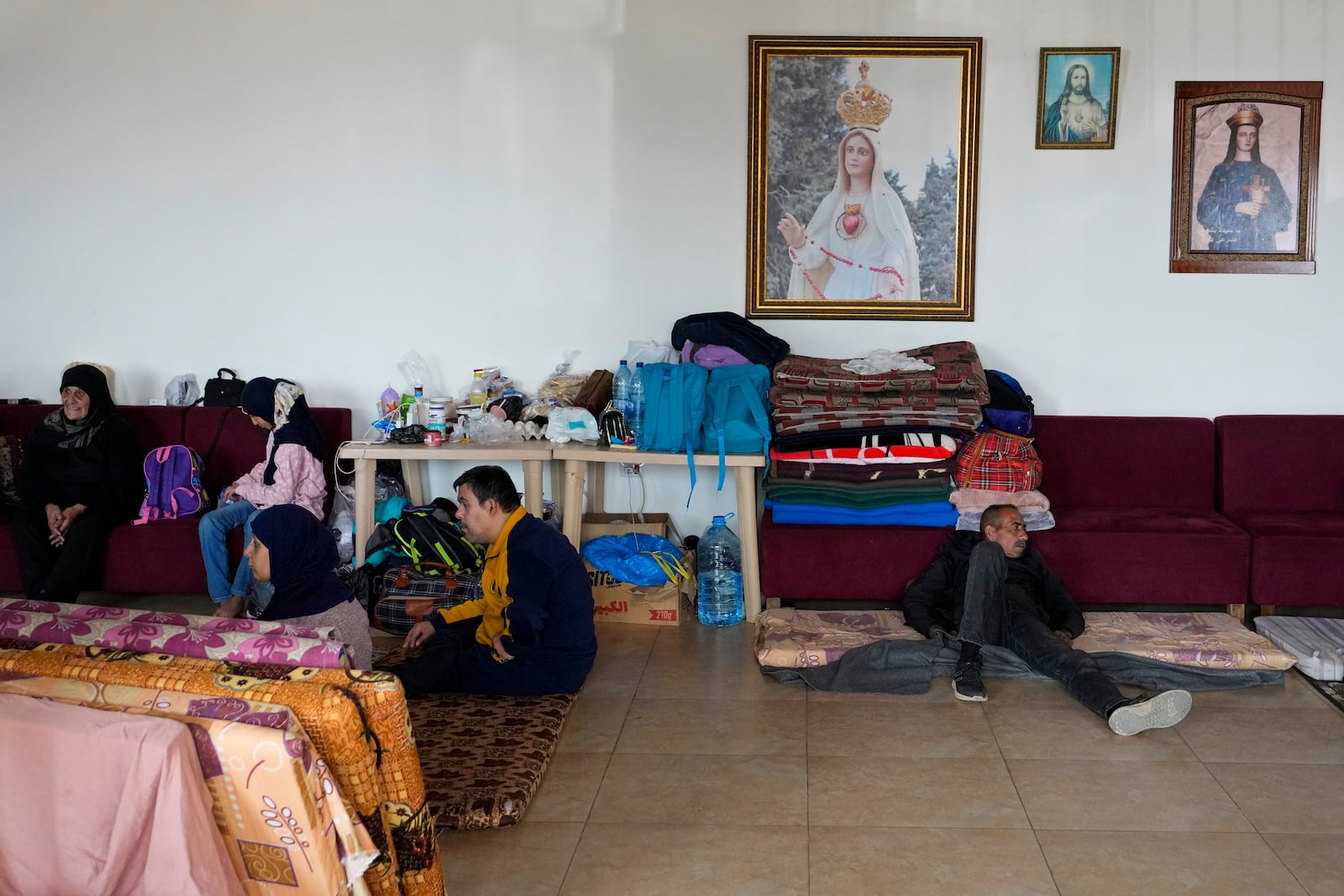 Displaced people, who fled Baalbek city and the nearby towns of Douris and Ain Bourday with their families amid the ongoing Hezbollah-Israel, take shelter inside a church sanctuary, in Deir Al-Ahmar, east Lebanon, Thursday, Oct. 31, 2024. (AP Photo/Hassan Ammar)