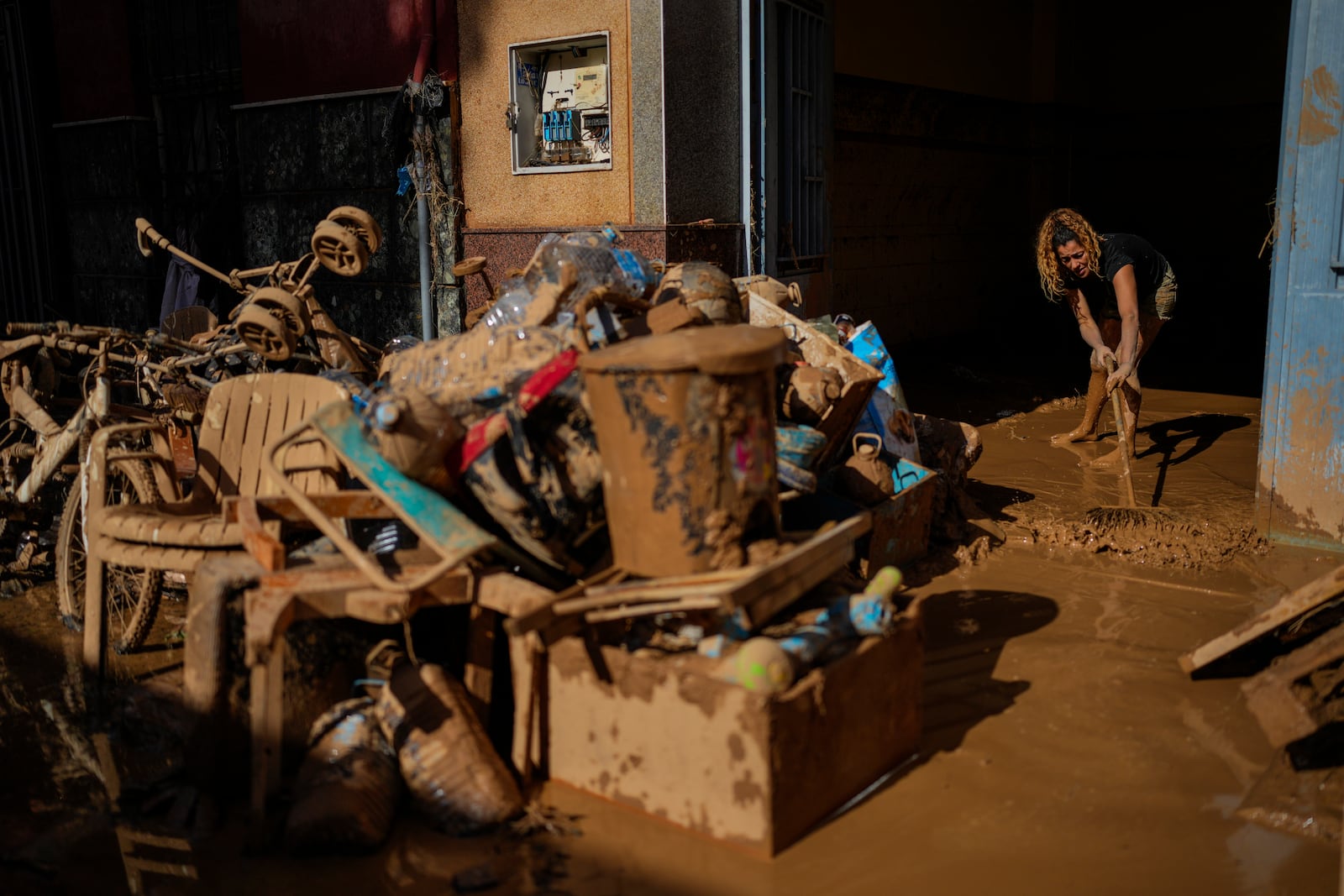 A woman cleans her house affected by floods in Valencia, Spain, Thursday, Oct. 31, 2024. (AP Photo/Manu Fernandez)