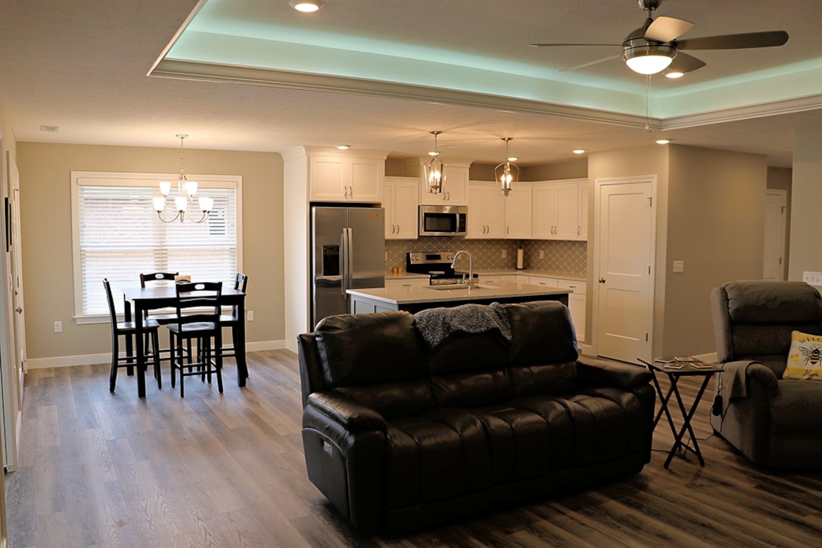 A large island with quartz counter divides the kitchen from the great room and foyer hallway.