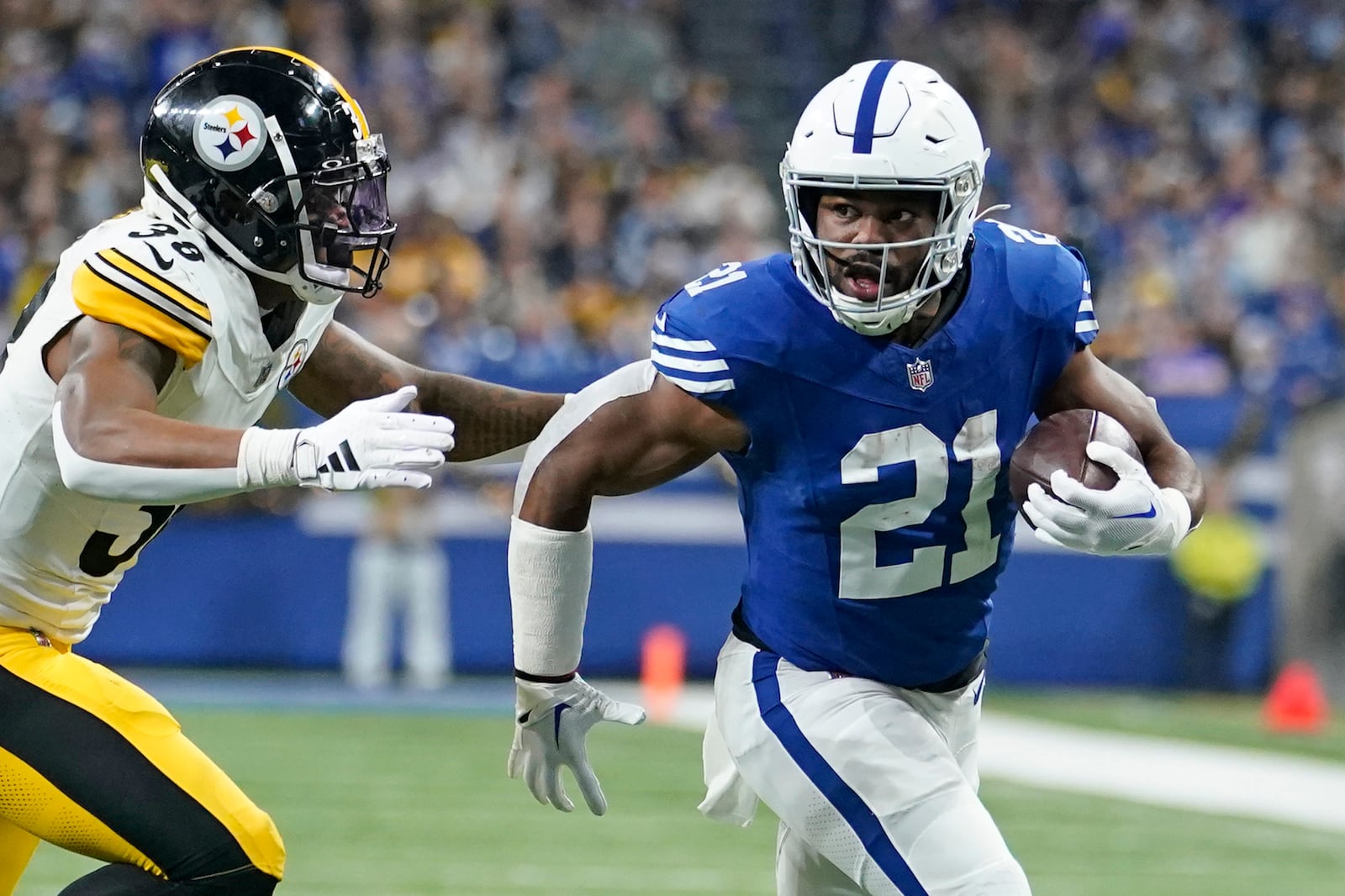 Indianapolis Colts running back Zack Moss (21) gets past Pittsburgh Steelers linebacker Mykal Walker (38) for a touchdown during the first half of an NFL football game in Indianapolis Saturday, Dec. 16, 2023. (AP Photo/Michael Conroy)