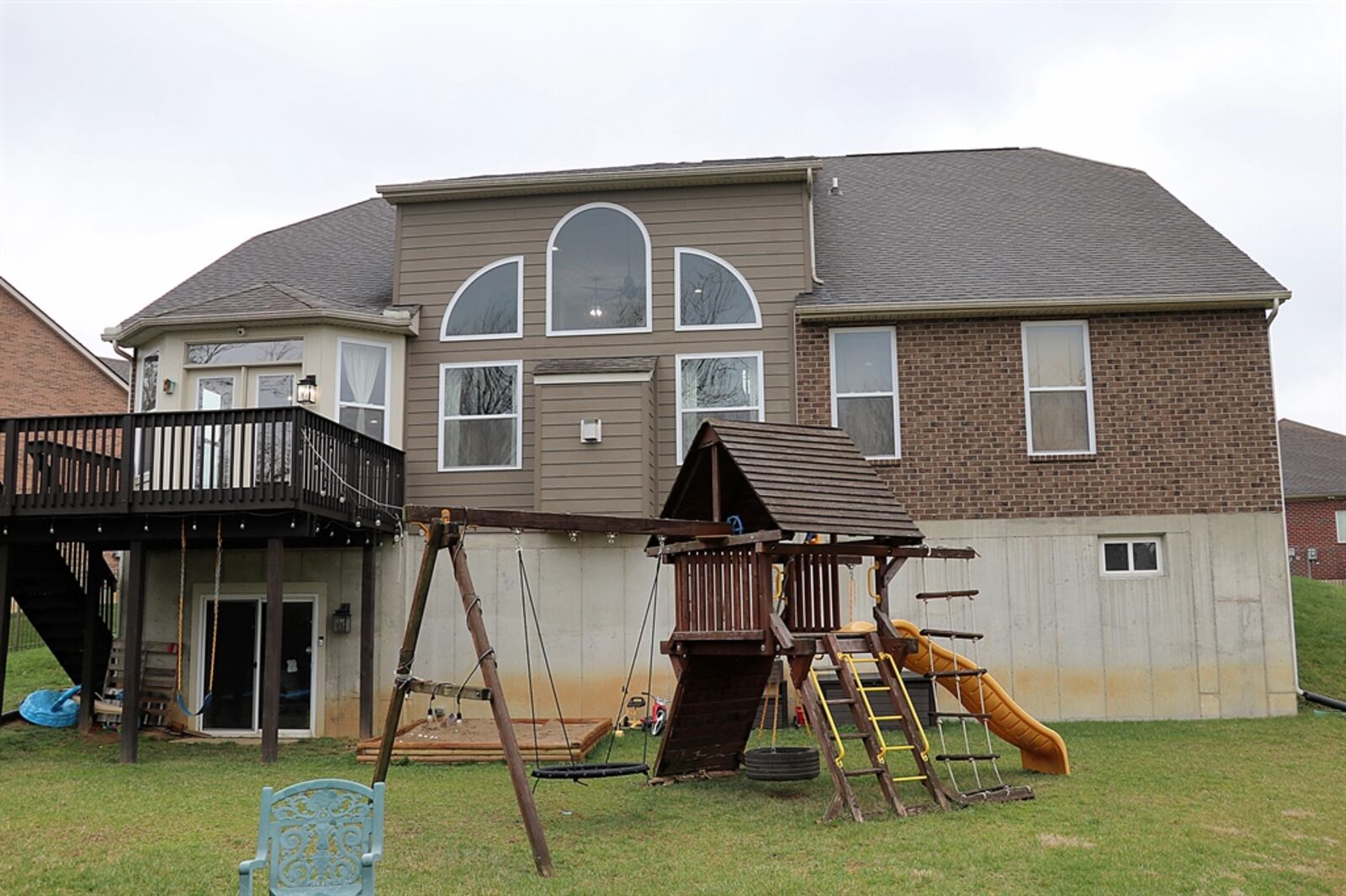 Sliding barn doors open to reveal patio doors that walkout to a small concrete patio and fenced backyard.