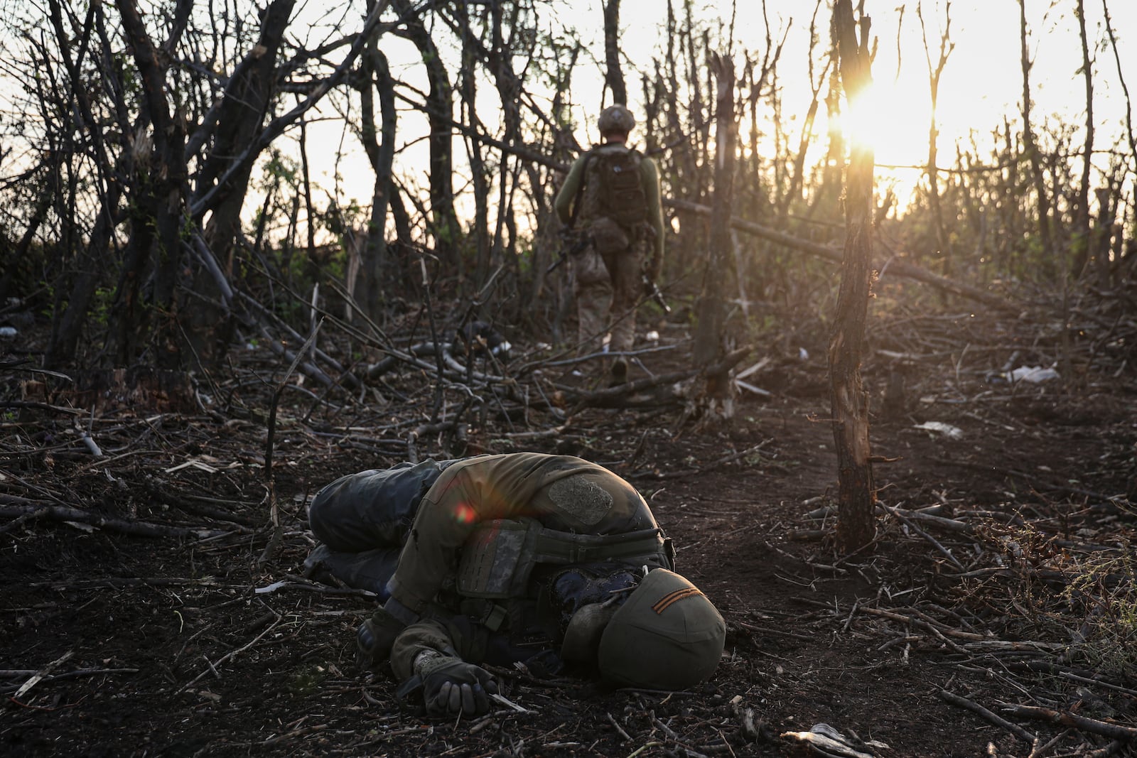 FILE - A Ukrainian assault unit commander passes by a dead Russian soldier on the front line near Andriivka, Ukraine, Saturday, Sept. 16, 2023. (AP Photo/Alex Babenko, File)