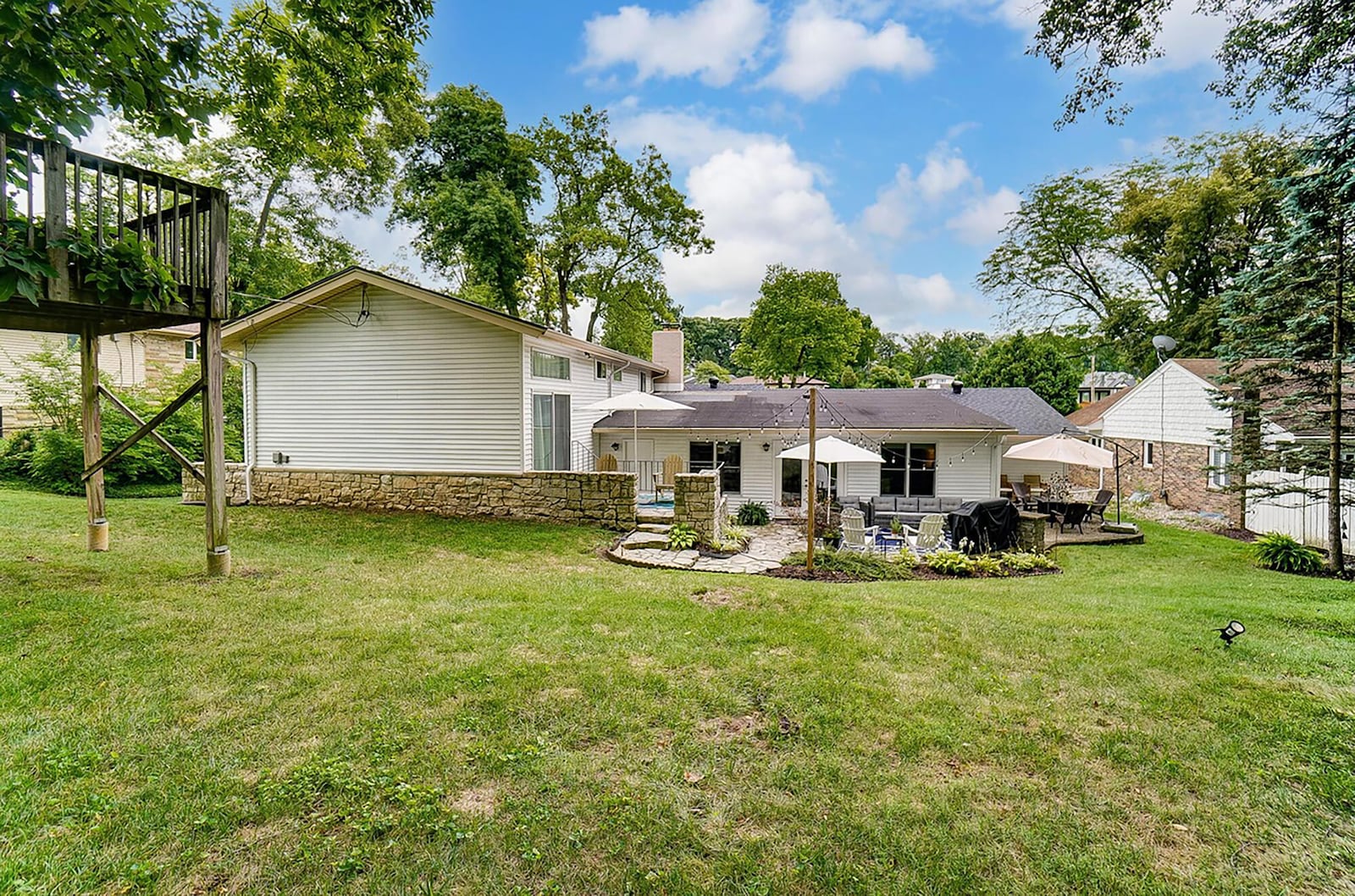 The rear of the home has multiple patios and seating areas, including an elevated patio, paver patio lower level area and gravel firepit area. There is another woodburning firepit area at the rear of the lot.