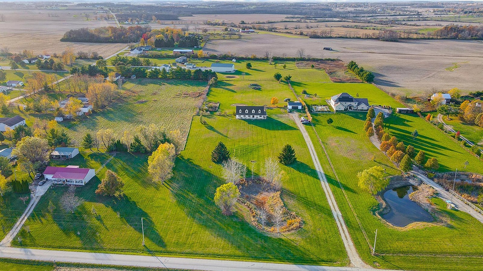 The home sits back from the road and has a two car detached garage and partial fence.