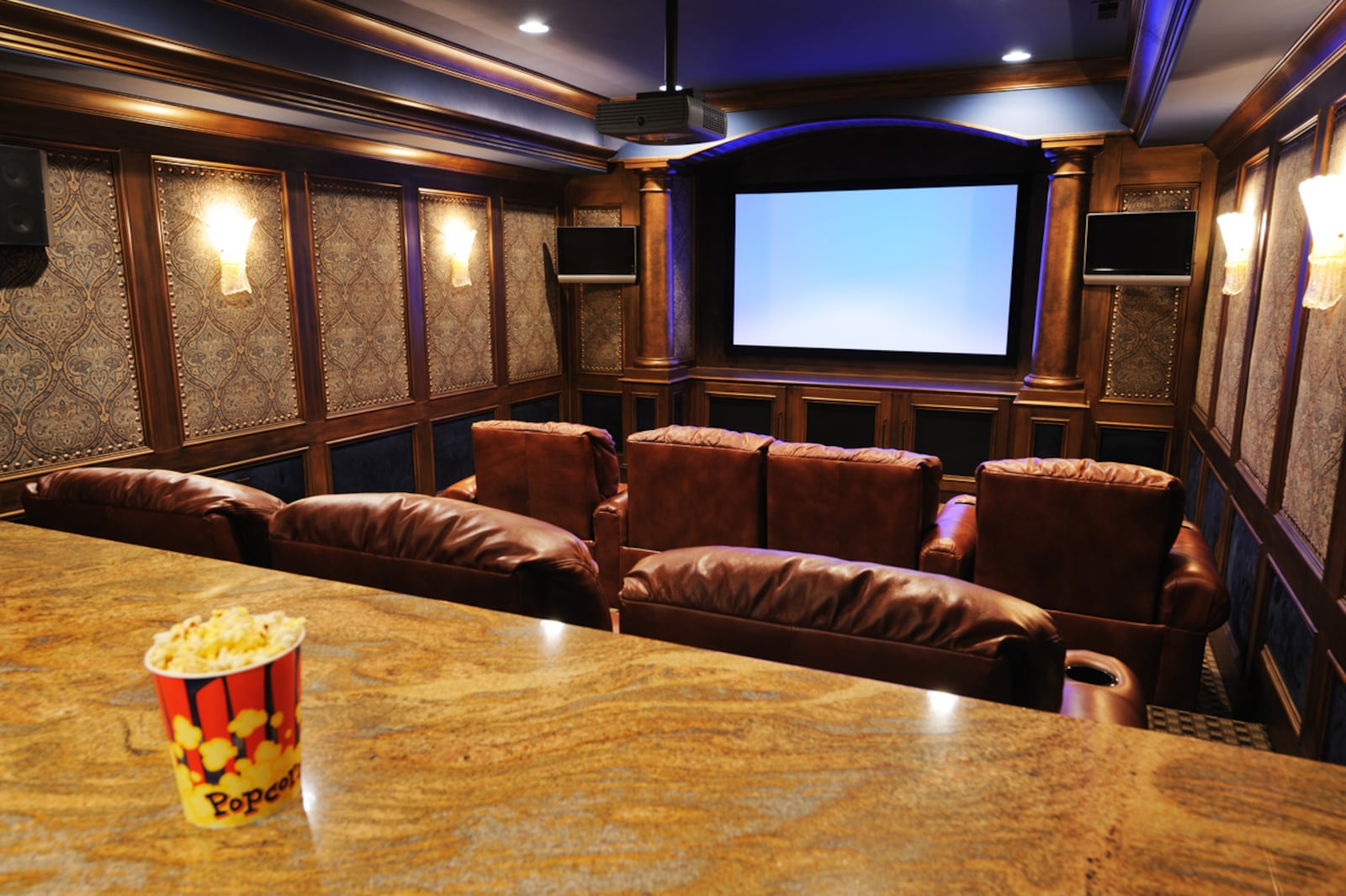 A bar at the rear of a home theater is ideal for placing appetizers, popcorn machines, drinks and for those who like to stand a bit when watching something on a bigger screen. iSTOCK PHOTO