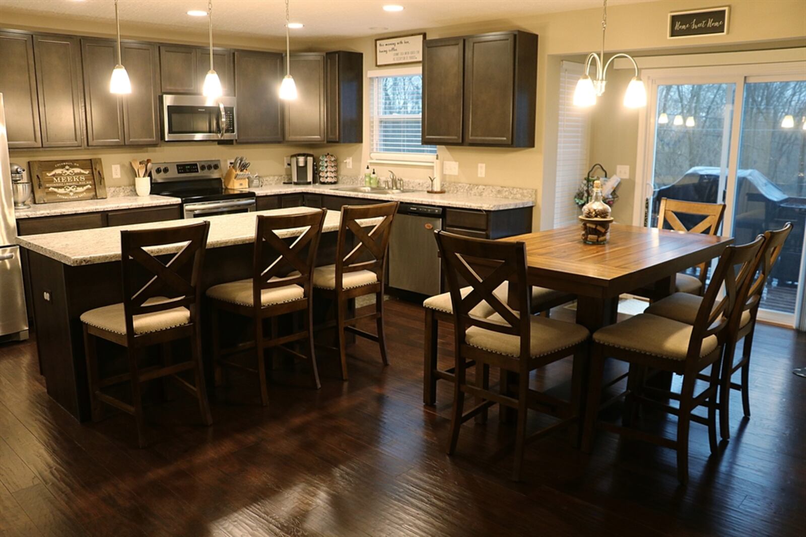 The kitchen and breakfast area have hardwood flooring that complements the cabinetry. The dining area has an extended bump-out with oversized sliding, patio doors and tall narrow windows that create a sunny nook. The patio doors open out to the wooden balcony deck.