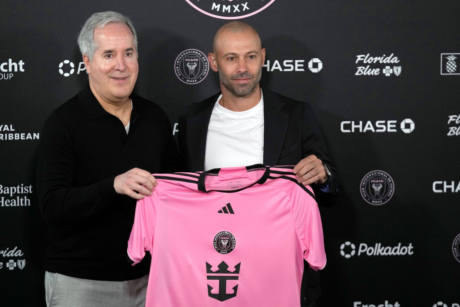 Inter Miami managing owner and CEO Jorge Mas, left, holds up a jersey as he introduces new head coach Javier Mascherano during an MLS soccer news conference, Tuesday, Dec. 3, 2024, in Fort Lauderdale, Fla. (AP Photo/Wilfredo Lee)