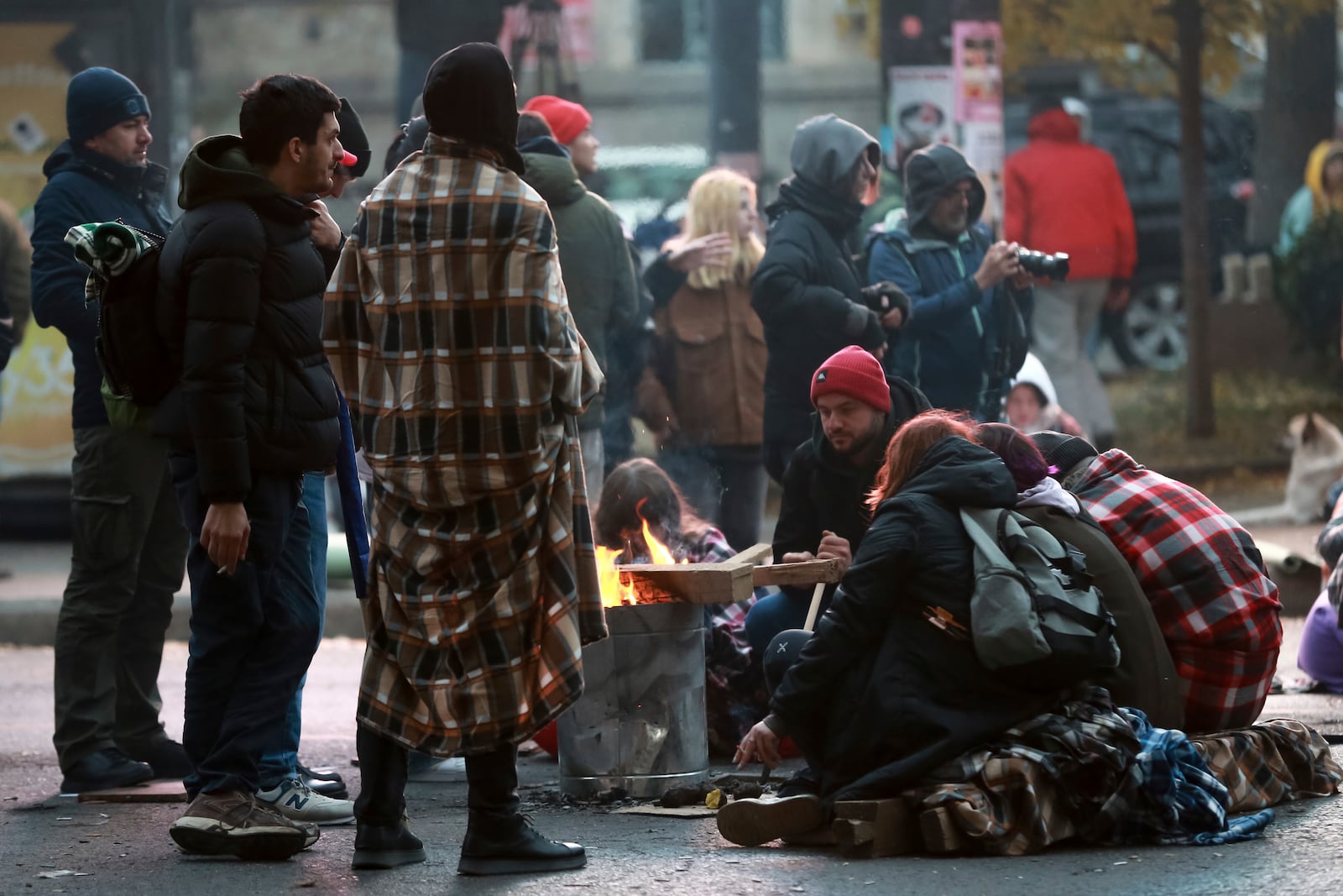 Protesters warm themselves at a bonfire during a rally against the results of the parliamentary elections amid allegations that the vote was rigged in Tbilisi, Georgia, Monday, Nov. 18, 2024. (AP Photo/Zurab Tsertsvadze)