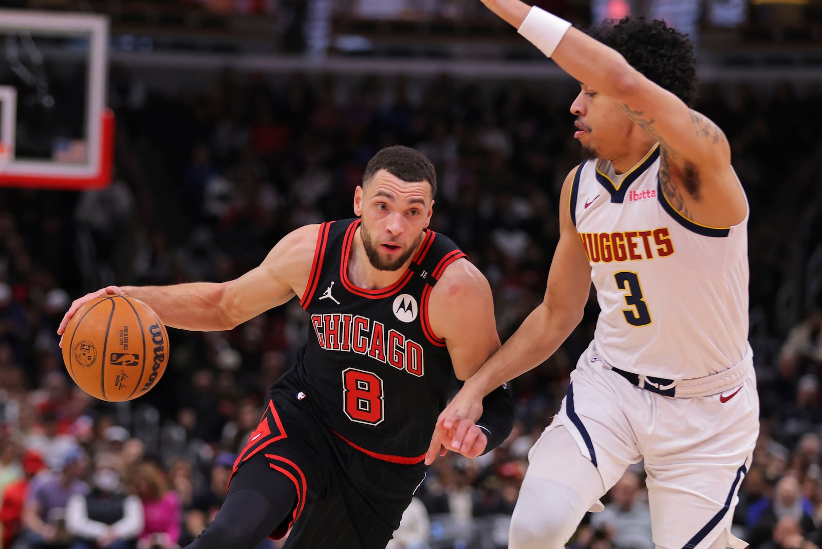 Chicago Bulls guard Zach LaVine (8) drives to the basket against Denver Nuggets guard Julian Strawther (3) during the first half of an NBA basketball game Monday, Jan. 27, 2025, in Chicago. (AP Photo/Melissa Tamez)