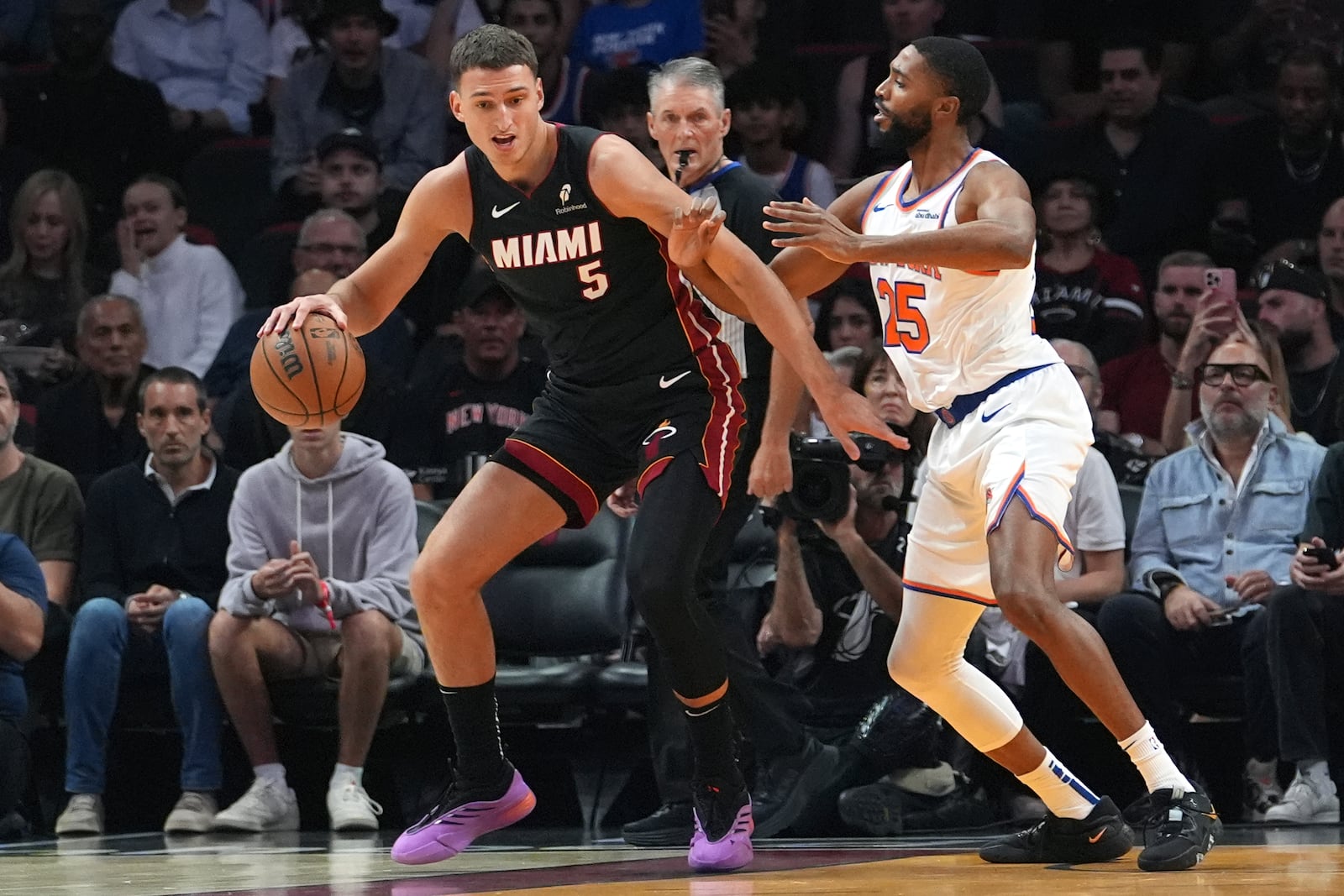 New York Knicks forward Mikal Bridges (25) defends Miami Heat forward Nikola Jovic (5) during the first half of an NBA basketball game, Wednesday, Oct. 30, 2024, in Miami. (AP Photo/Lynne Sladky)