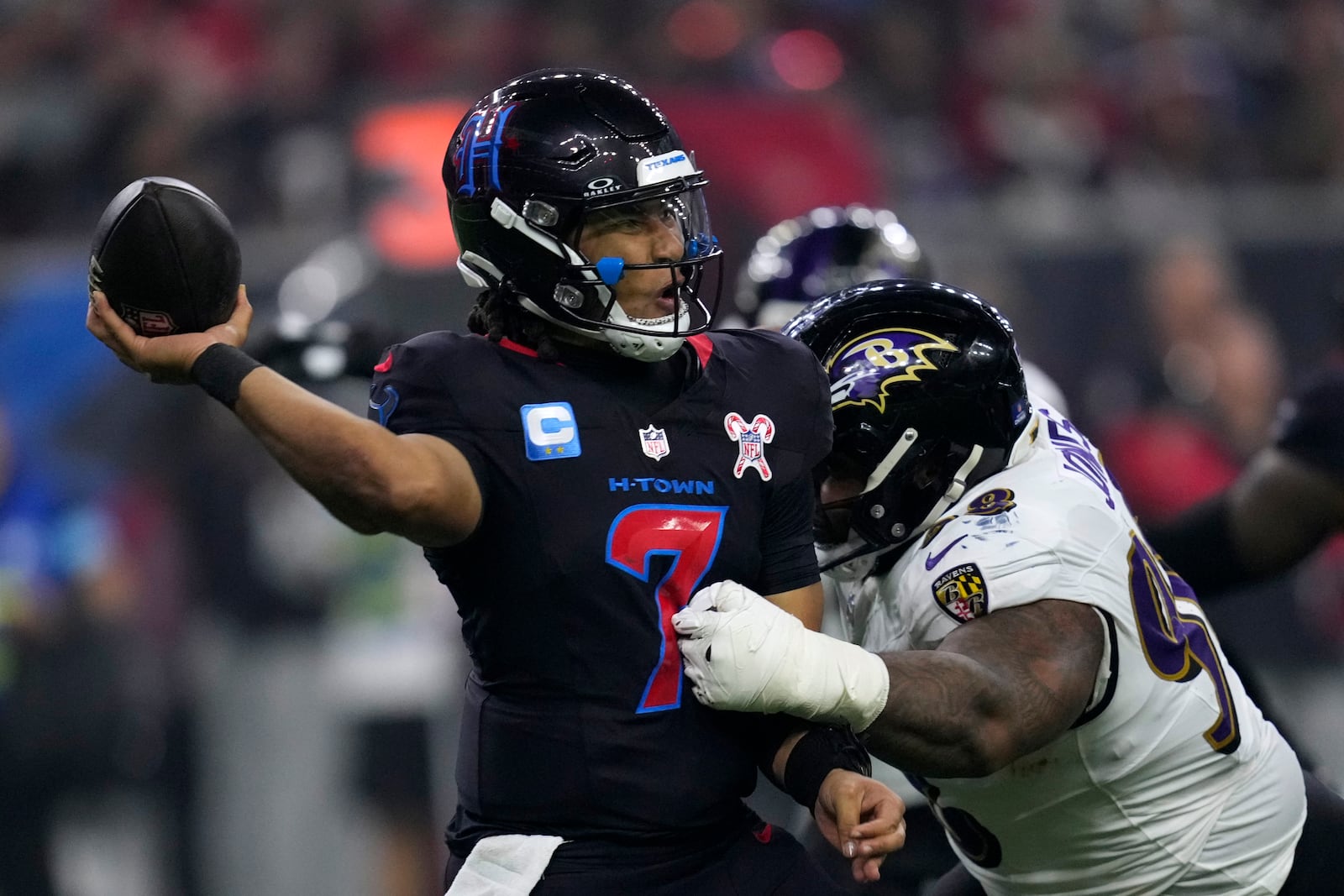 Houston Texans quarterback C.J. Stroud (7) passes as he is pressured by Baltimore Ravens defensive tackle Travis Jones (98) during the second half of an NFL football game, Wednesday, Dec. 25, 2024, in Houston. (AP Photo/David J. Phillip)