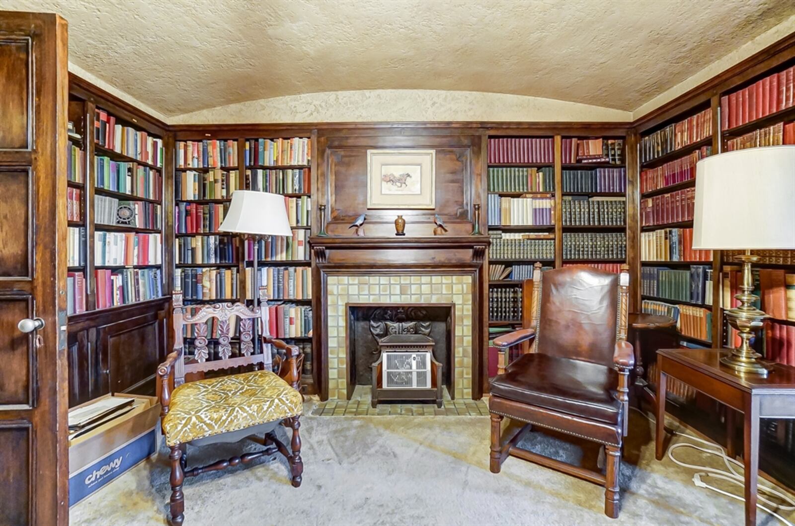 From the main bedroom, a pocket door opens into the library that also has access to the hallway. The library has built-in bookcases, which surround a decorative fireplace. 