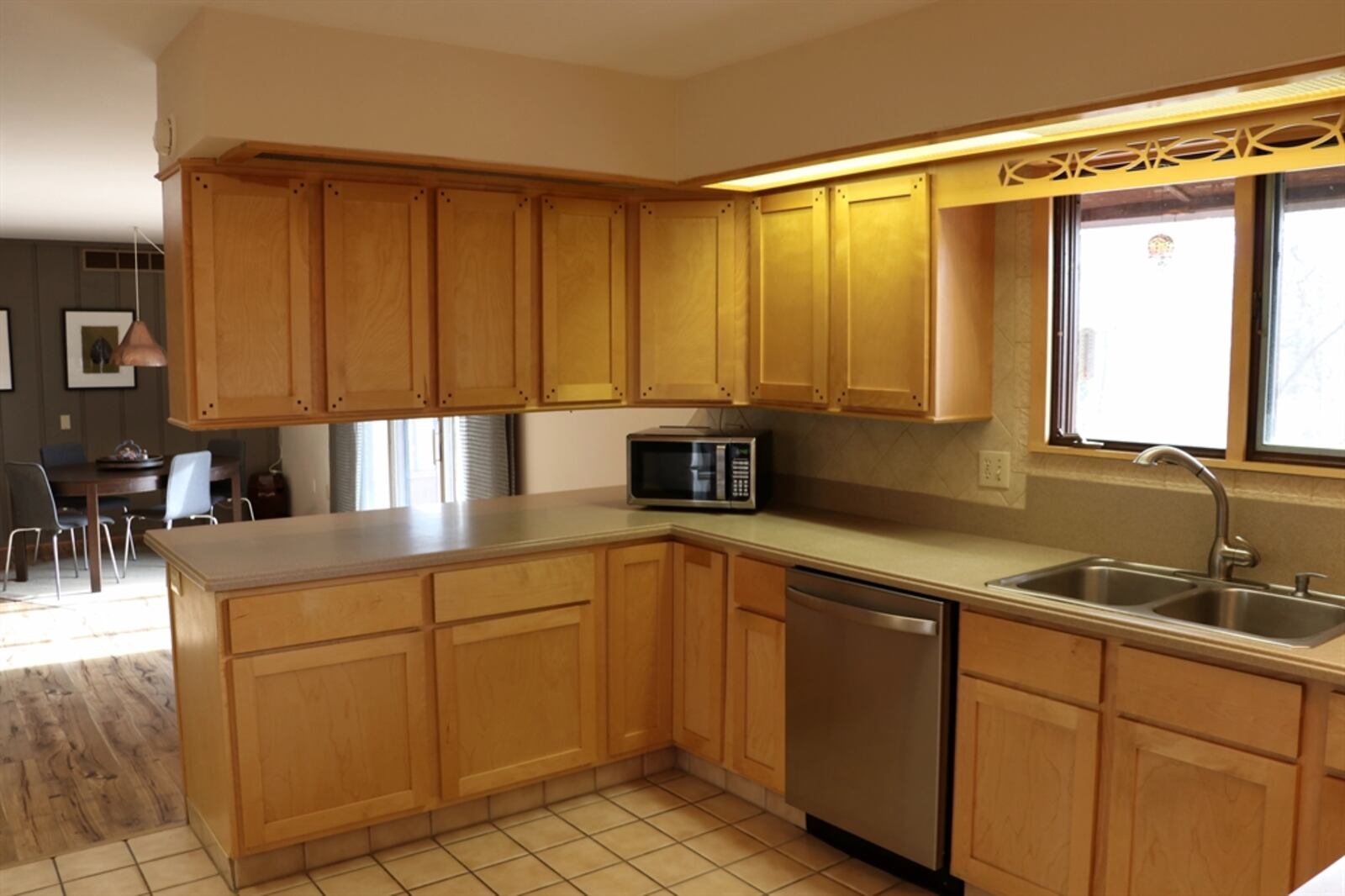 Light wood cabinetry surrounds the U-shaped kitchen, offering a planning area, breakfast bar seating and hidden storage nooks. CONTRIBUTED BY KATHY TYLER