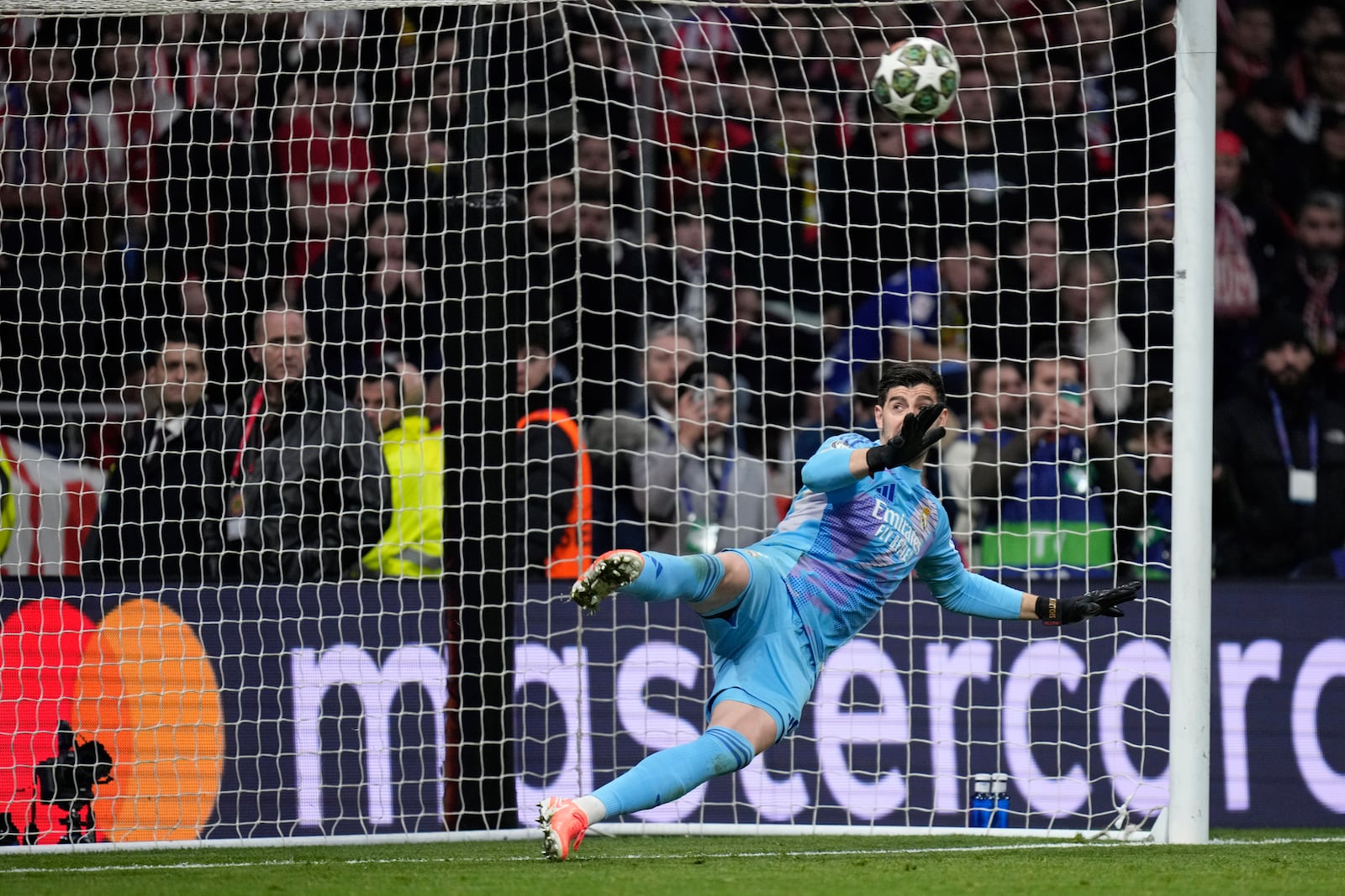 Real Madrid goalkeeper Thibaut Courtois fails to stop a penalty kick by Atletico Madrid's Julian Alvarez during a shootout at the end of the Champions League round of 16, second leg, soccer match between Atletico Madrid and Real Madrid at the Metropolitano stadium in Madrid, Spain, Wednesday, March 12, 2025. (AP Photo/Bernat Armangue)